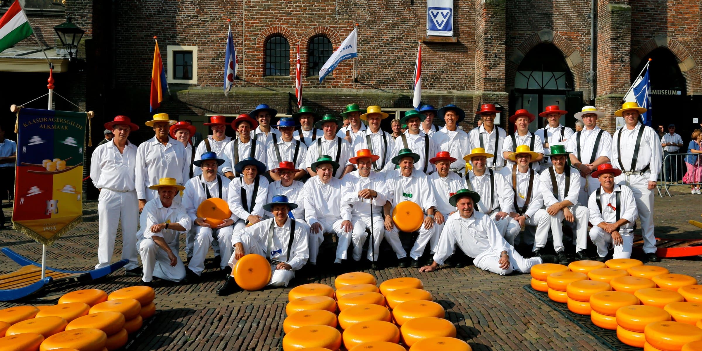 Traditional white-uniformed cheese porters of the Kaasdragers Gilde carrying cheese barrows at the Alkmaar Waagplein