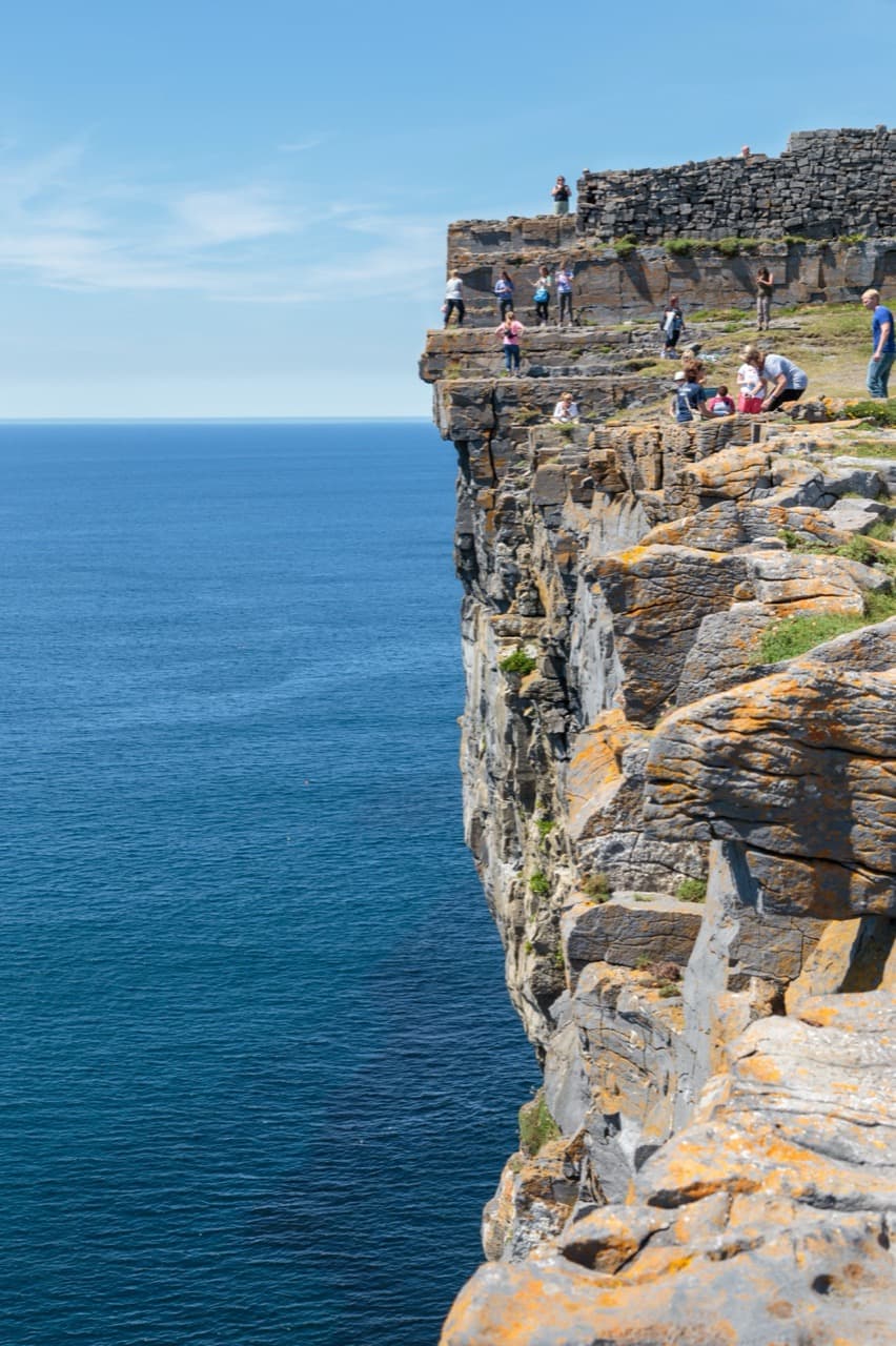 The colossal prehistoric semi-circular stone ramparts of Dún Aonghasa clinging to the edge of a sheer 100-metre Atlantic cliff on Inishmore