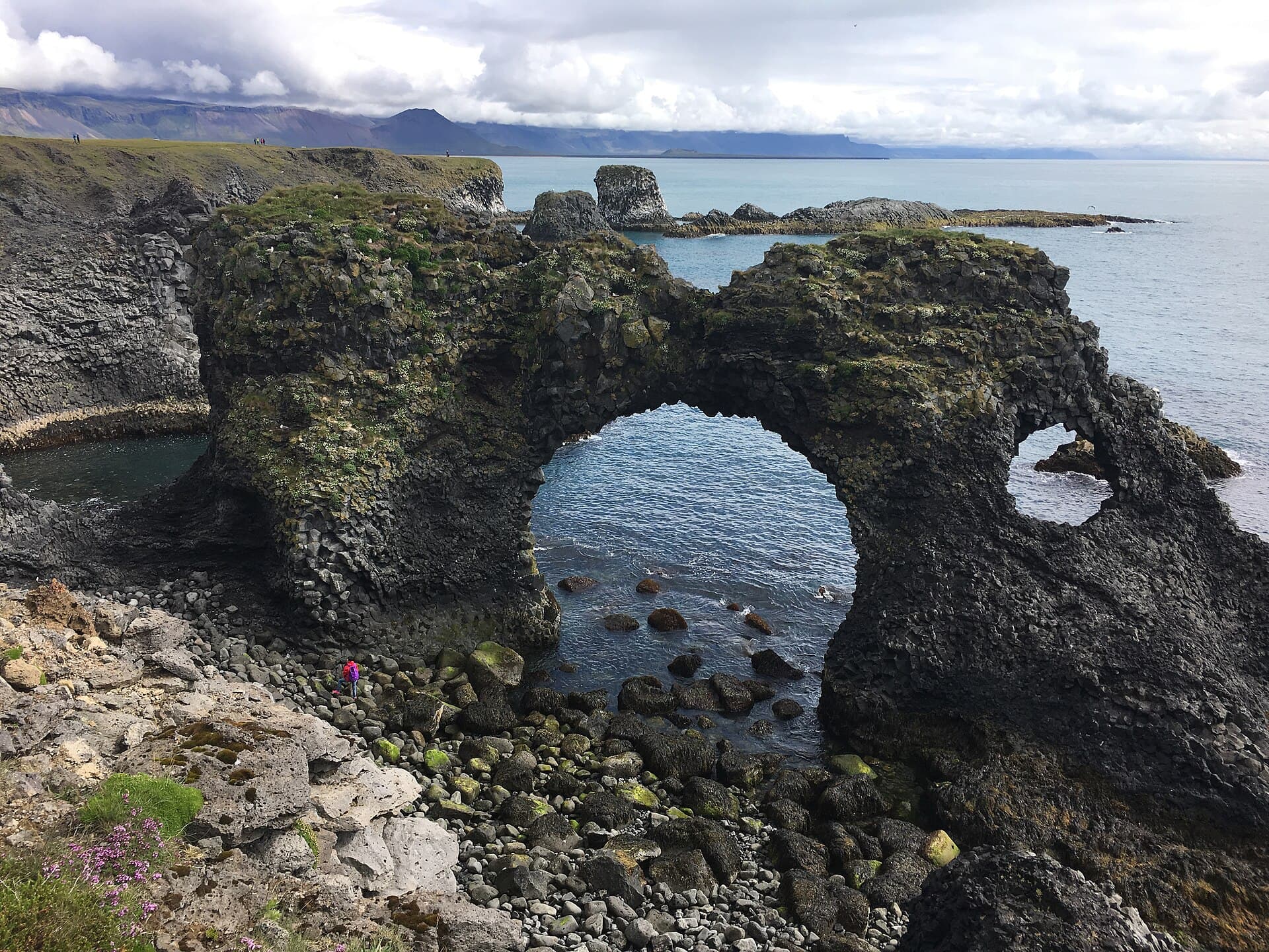 Spectacular natural basalt sea arch of Gatklettur carved by ocean waves along the cliffs of Arnarstapi