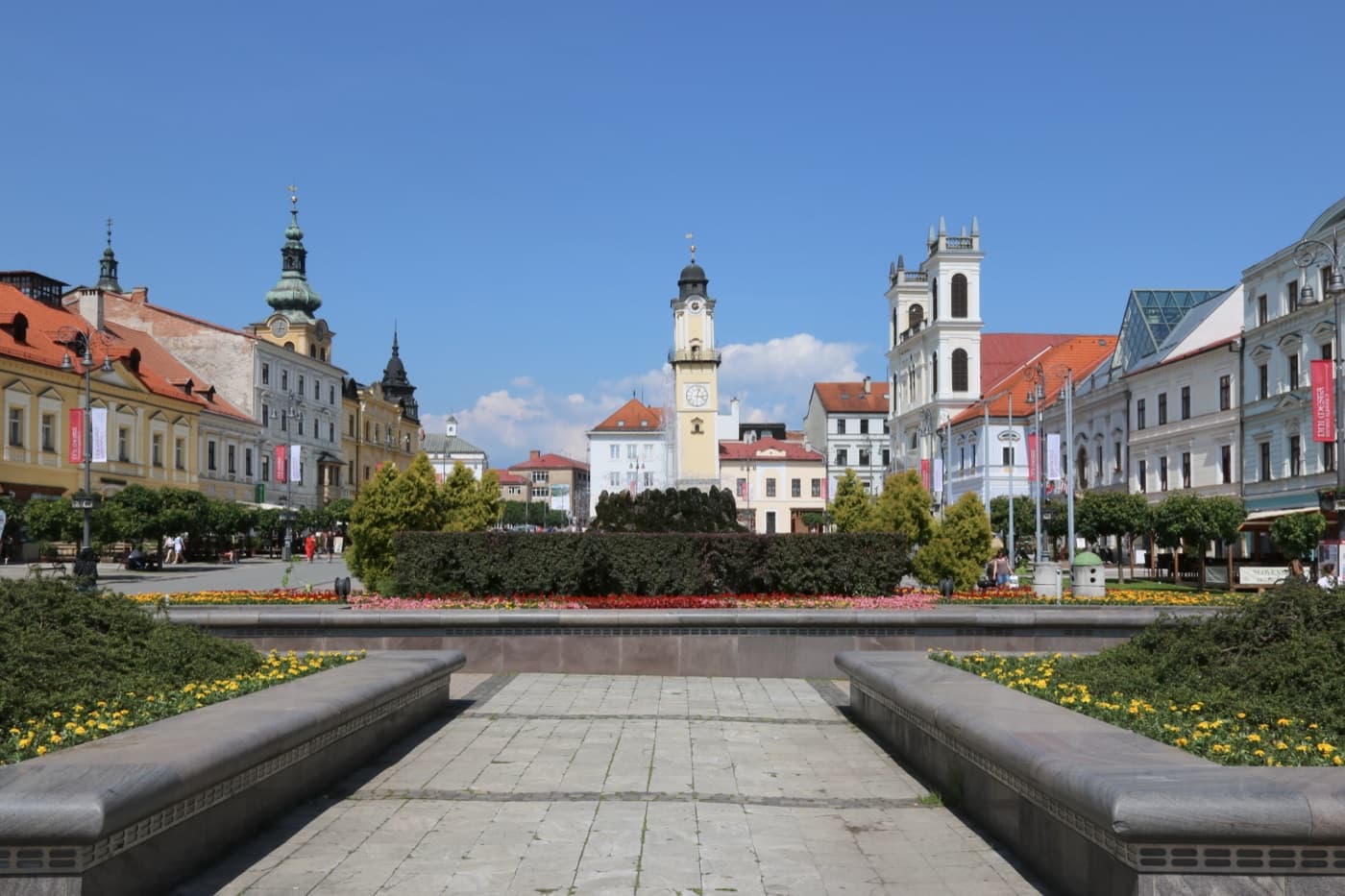 The pastel townhouses, leaning clock tower, and mountain backdrop of SNP Square in Banská Bystrica