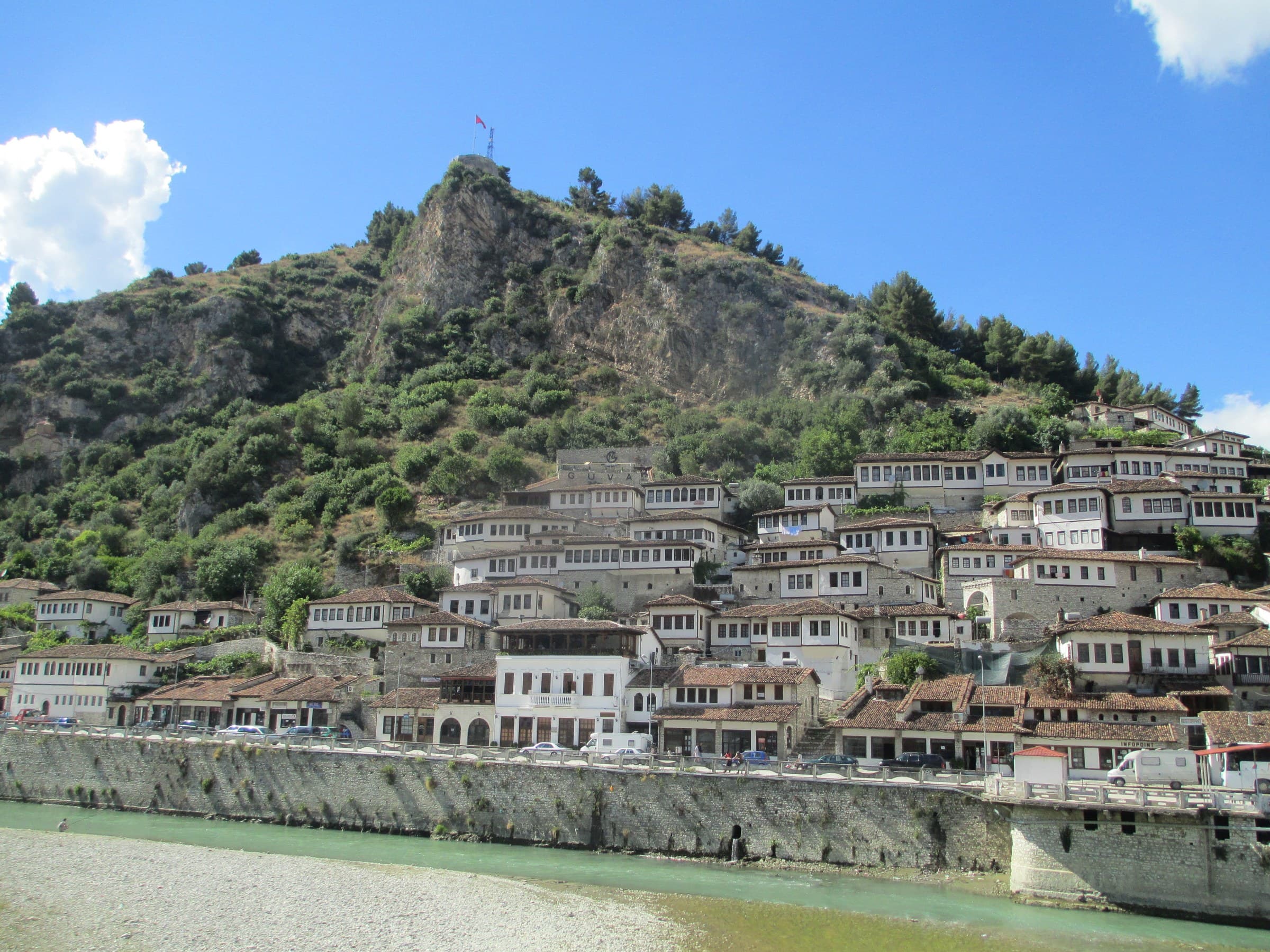 Tiers of whitewashed Ottoman stone houses with multiple arched windows in the Mangalem quarter of Berat