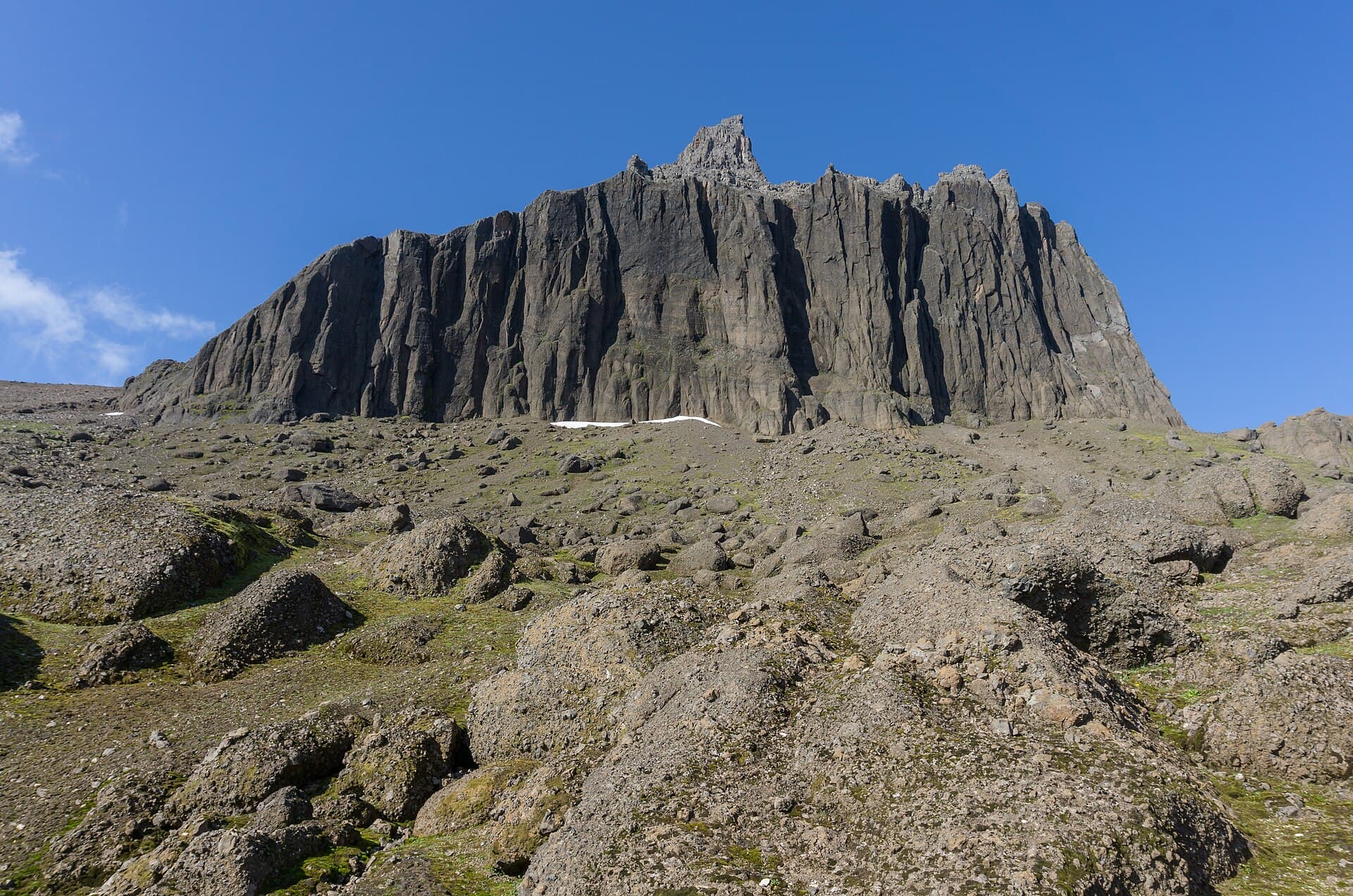 Spectacular jagged volcanic peaks of Dyrfjöll towering above the coastal meadows of Borgarfjörður Eystri