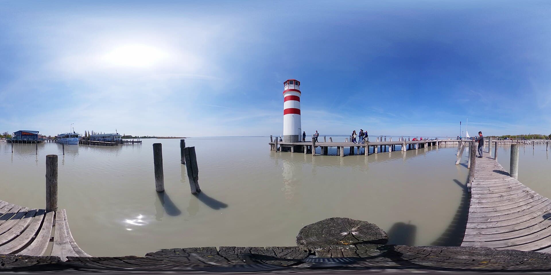Red and white lighthouse standing at the end of the wooden jetty at Podersdorf on Lake Neusiedl in Burgenland