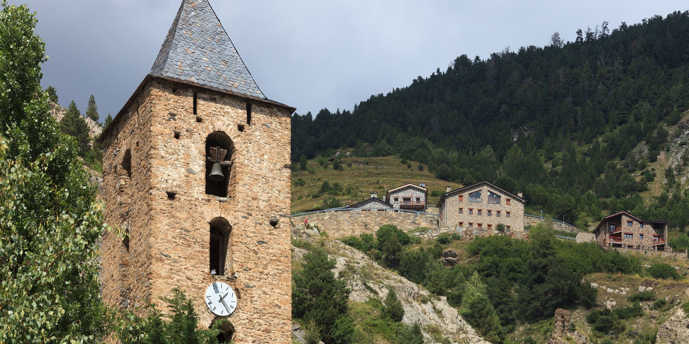 The bell tower of Sant Serni de Canillo with the mountains of the Valira valley behind