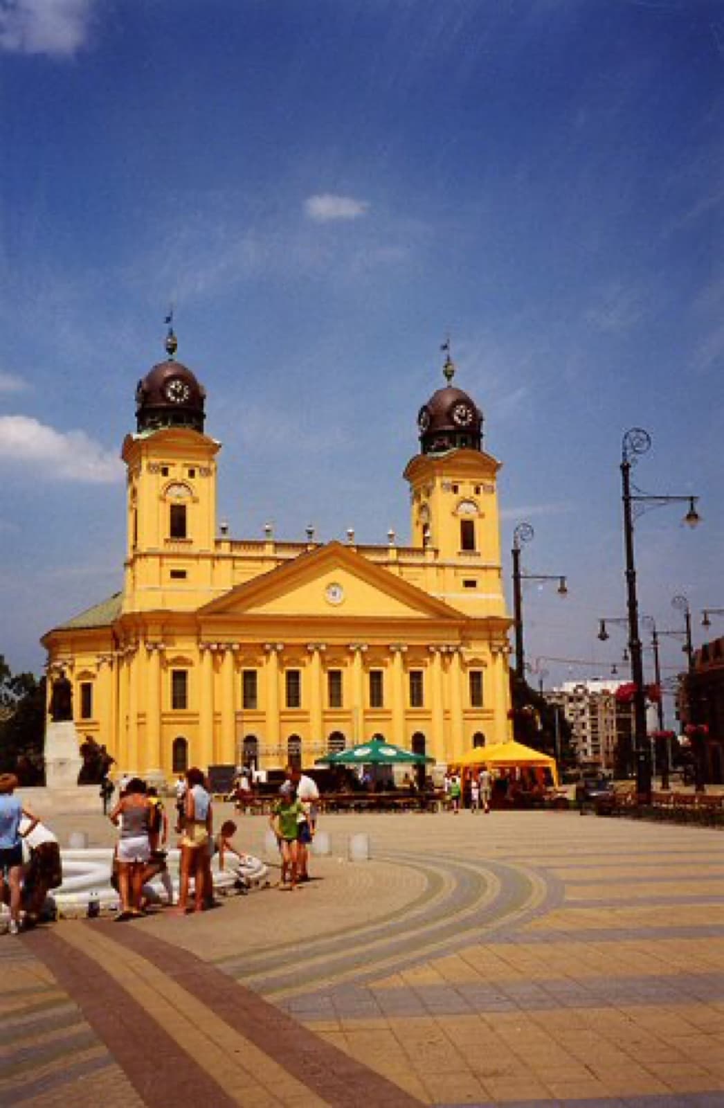 The imposing yellow Neoclassical twin towers of the Reformed Great Church dominating Kossuth Square in Debrecen