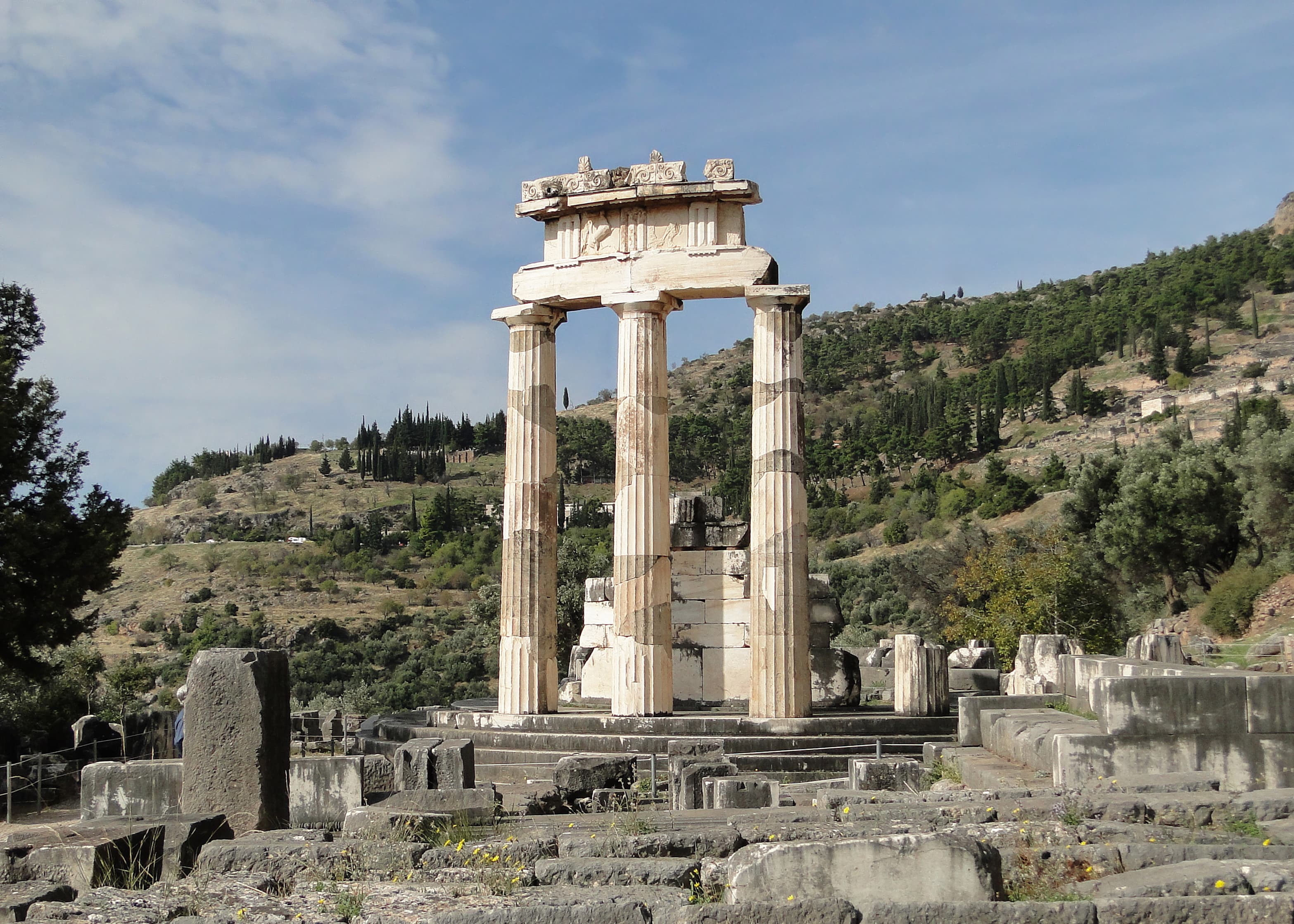 The circular Tholos of Athena Pronaia standing against Mount Parnassus in Delphi