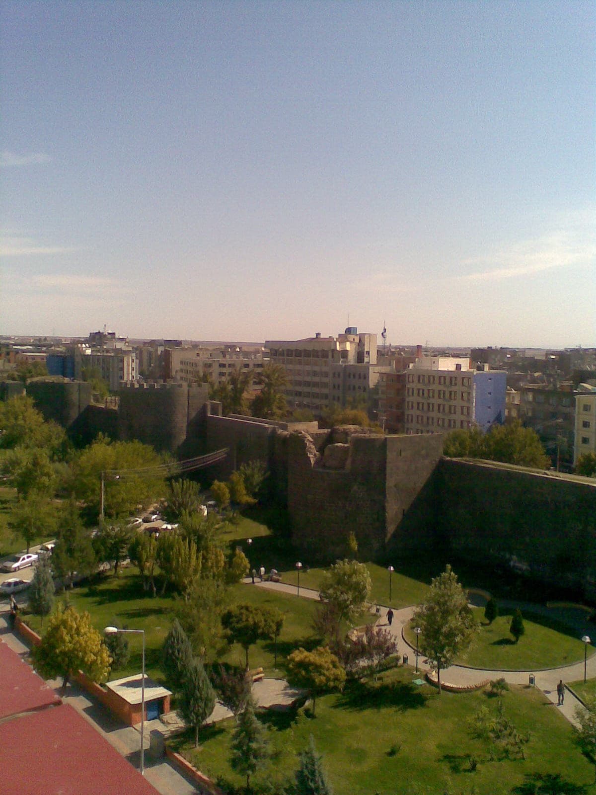Monumental black basalt city walls of Diyarbakır overlooking the lush green UNESCO Hevsel Gardens and Tigris River