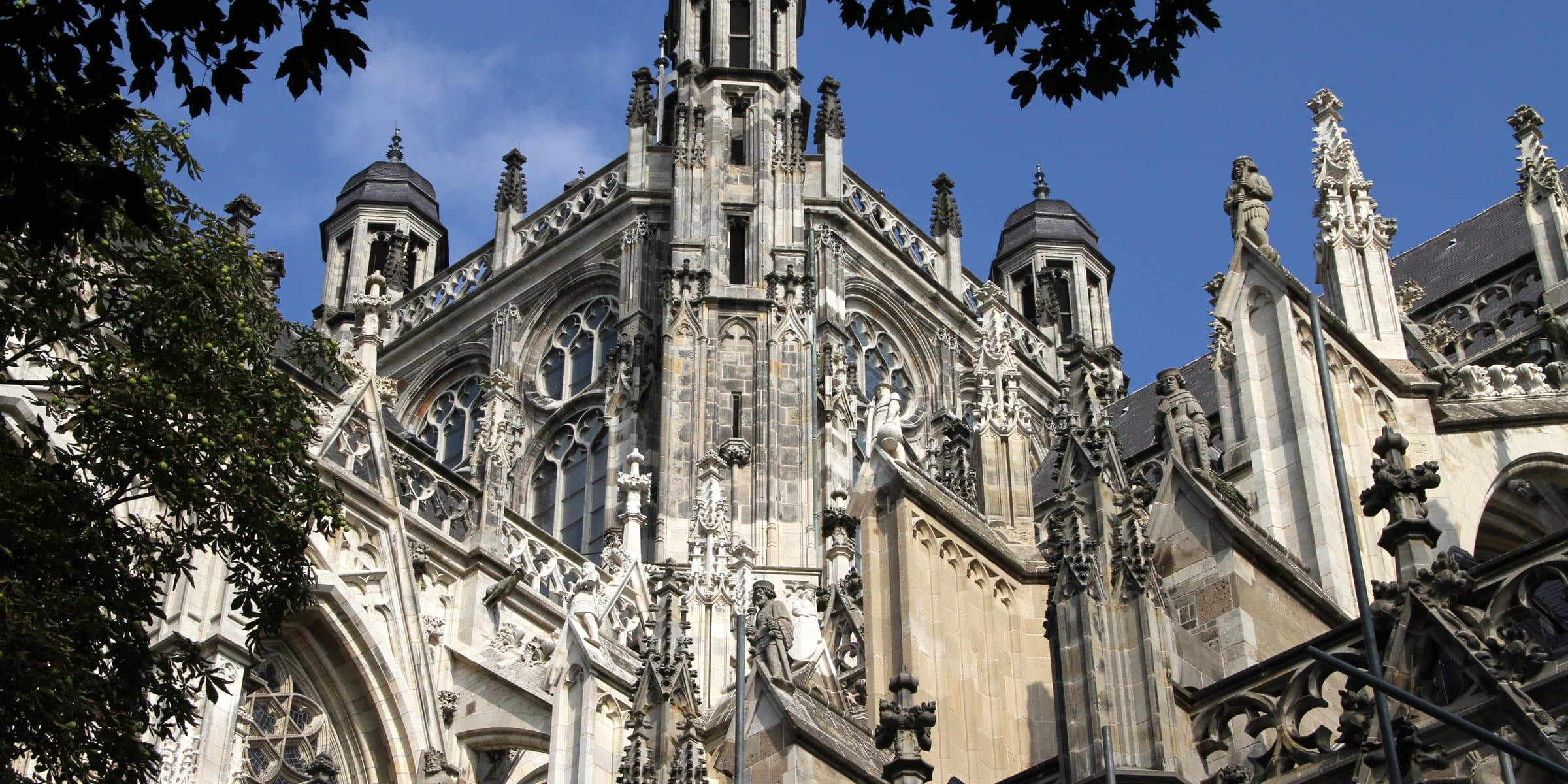 The ornate Gothic flying buttresses, stone figurines and roof arches of Sint-Janskathedraal in 's-Hertogenbosch