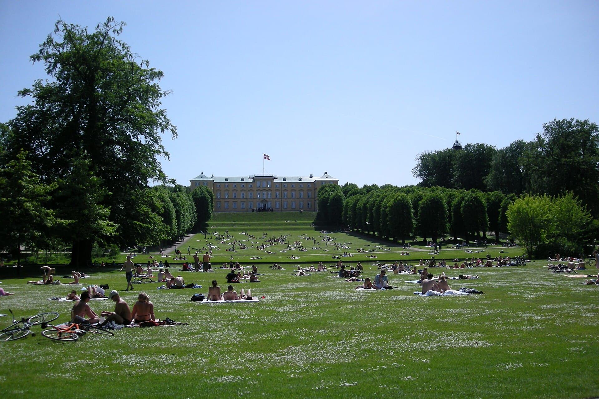 The ochre facade of Frederiksberg Palace overlooking the romantic canals and lawns of Frederiksberg Gardens.