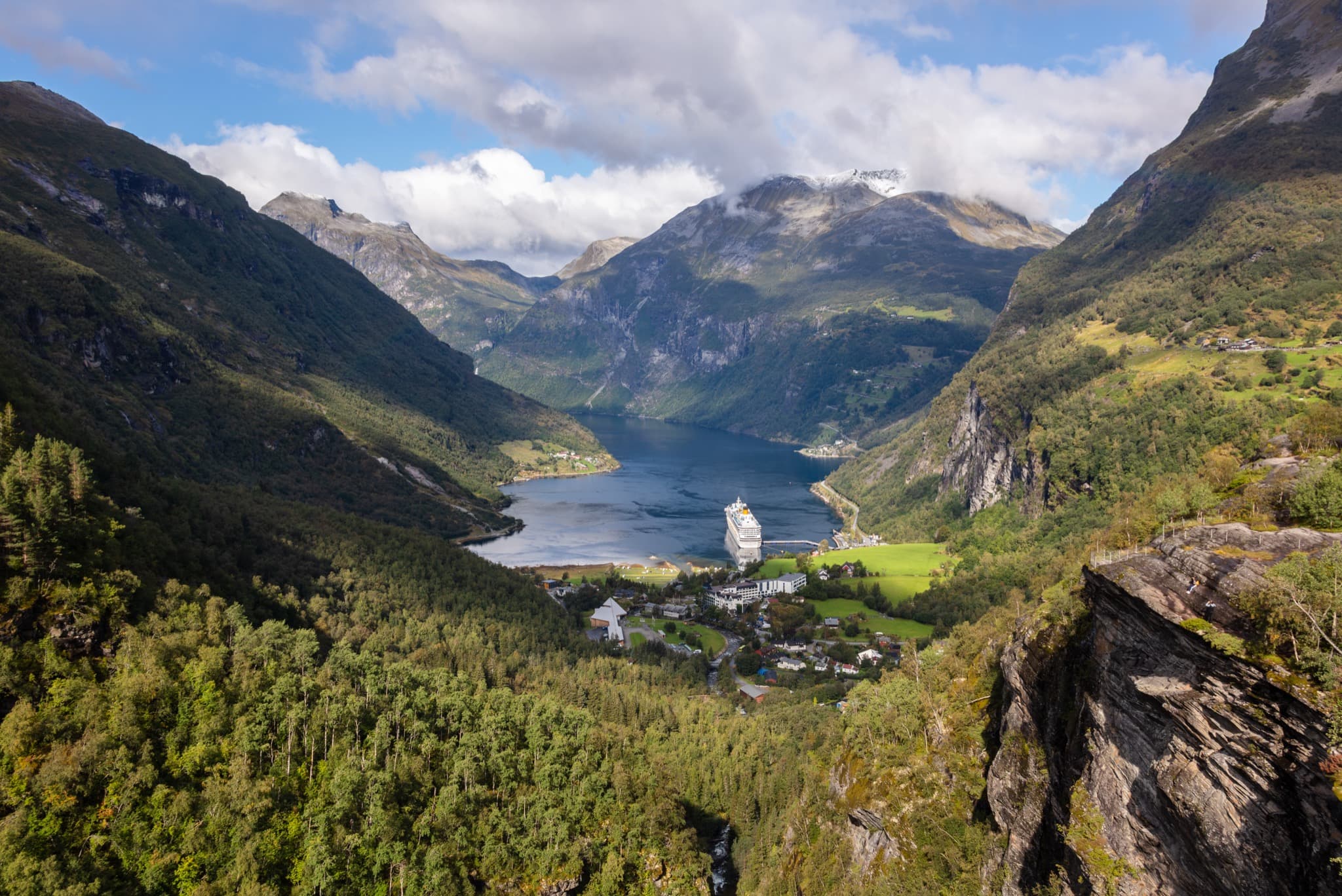 Deep blue serpentine curves of Geirangerfjord framed by soaring peaks and waterfalls near Ålesund