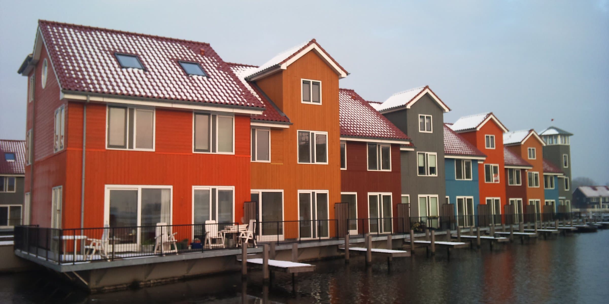 Brightly coloured waterside Scandinavian-style houses reflected in the marina at Reitdiephaven in Groningen
