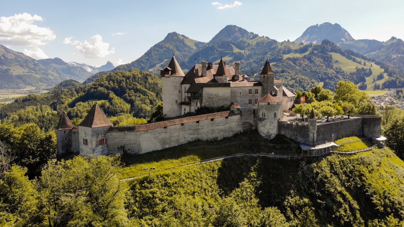 Medieval Château de Gruyères crowning a green hilltop against the Pre-Alps