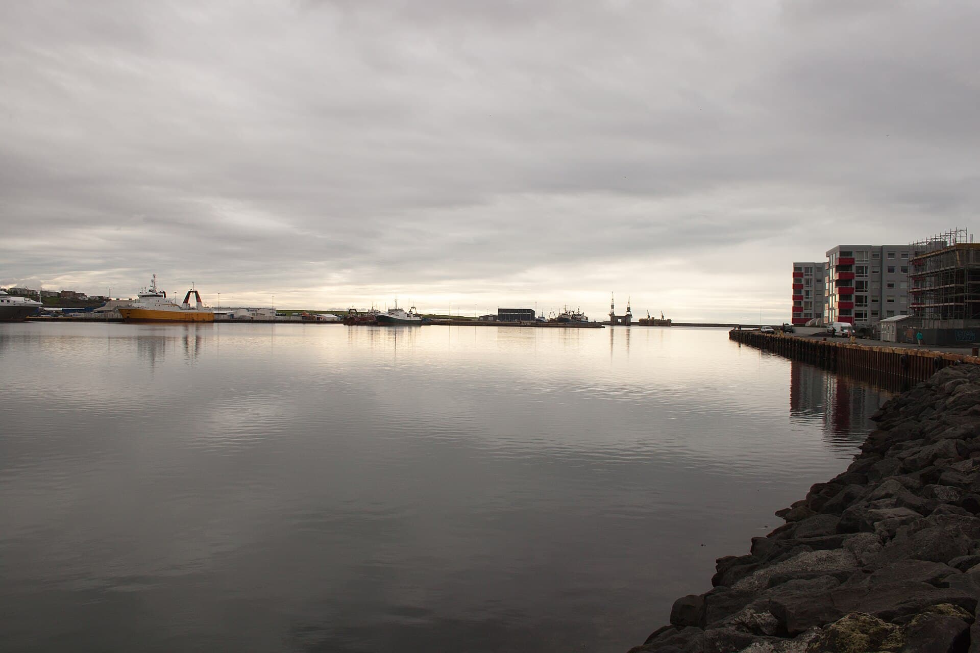 Colorful fishing boats and wooden waterfront buildings around the harbor of Hafnarfjörður