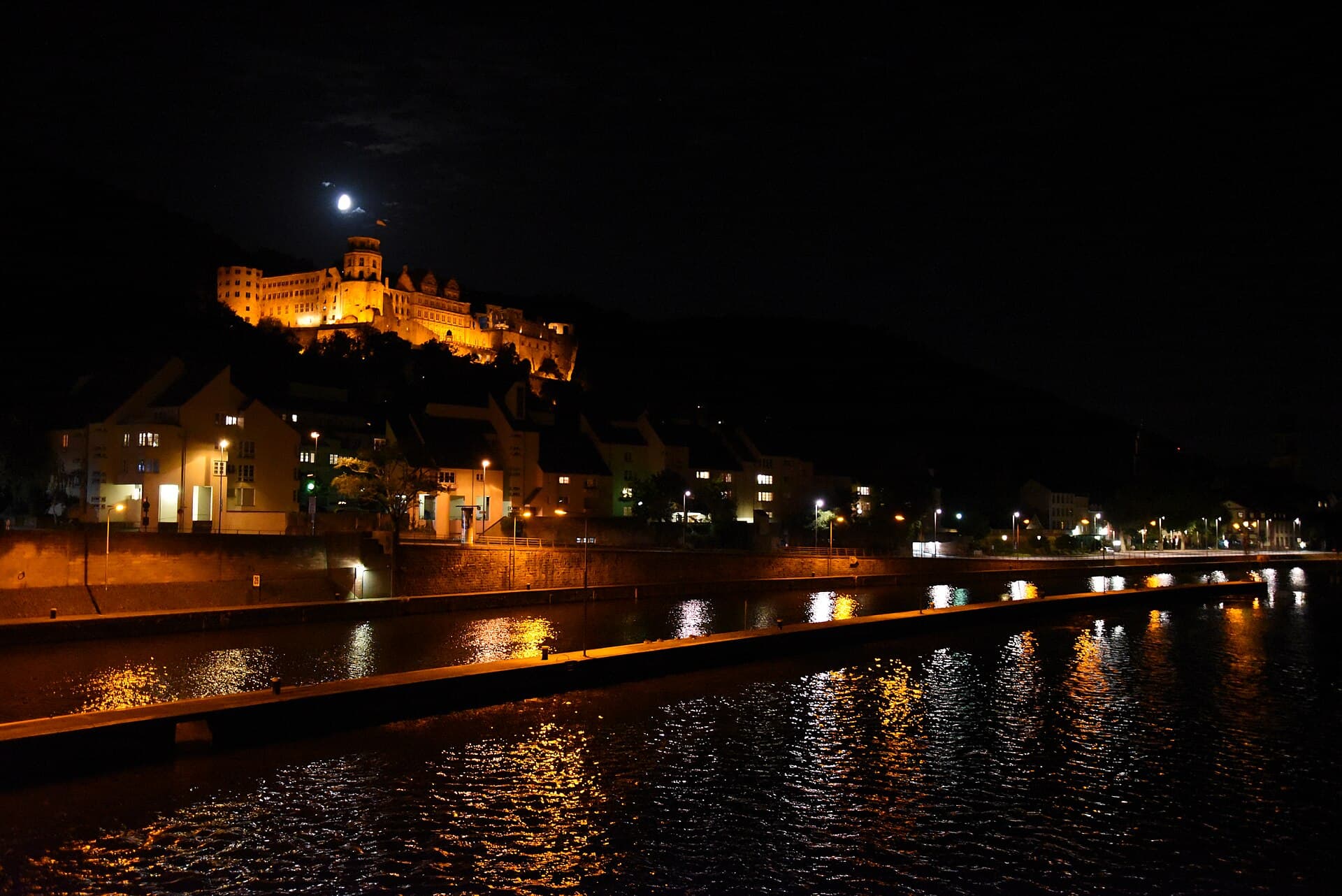 Illuminated ruins of Heidelberg Castle overlooking the Neckar river at dusk