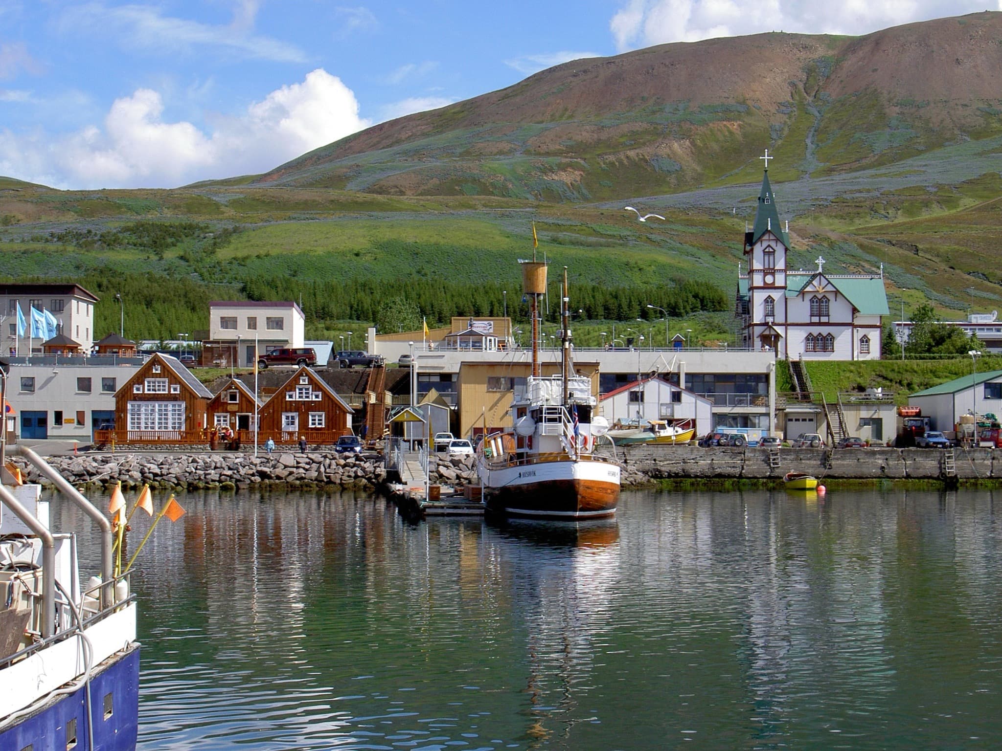 Húsavík harbour and church backed by snow-dusted mountains across Skjálfandi Bay