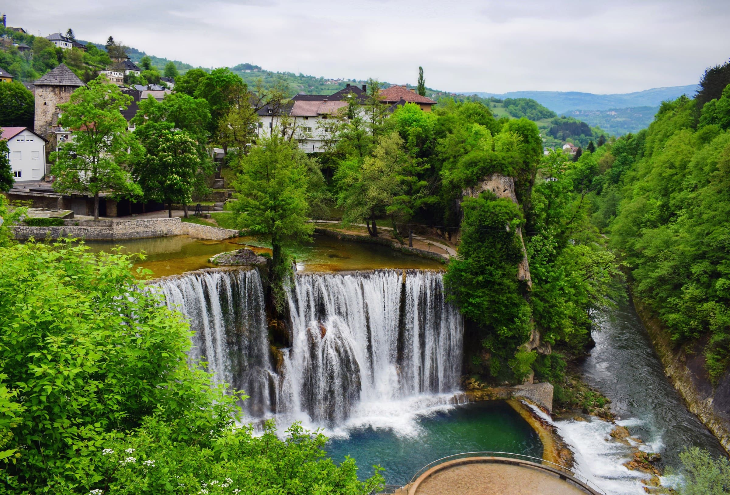 Dramatic 21-metre Pliva Waterfall thundering directly below the medieval walled citadel of Jajce