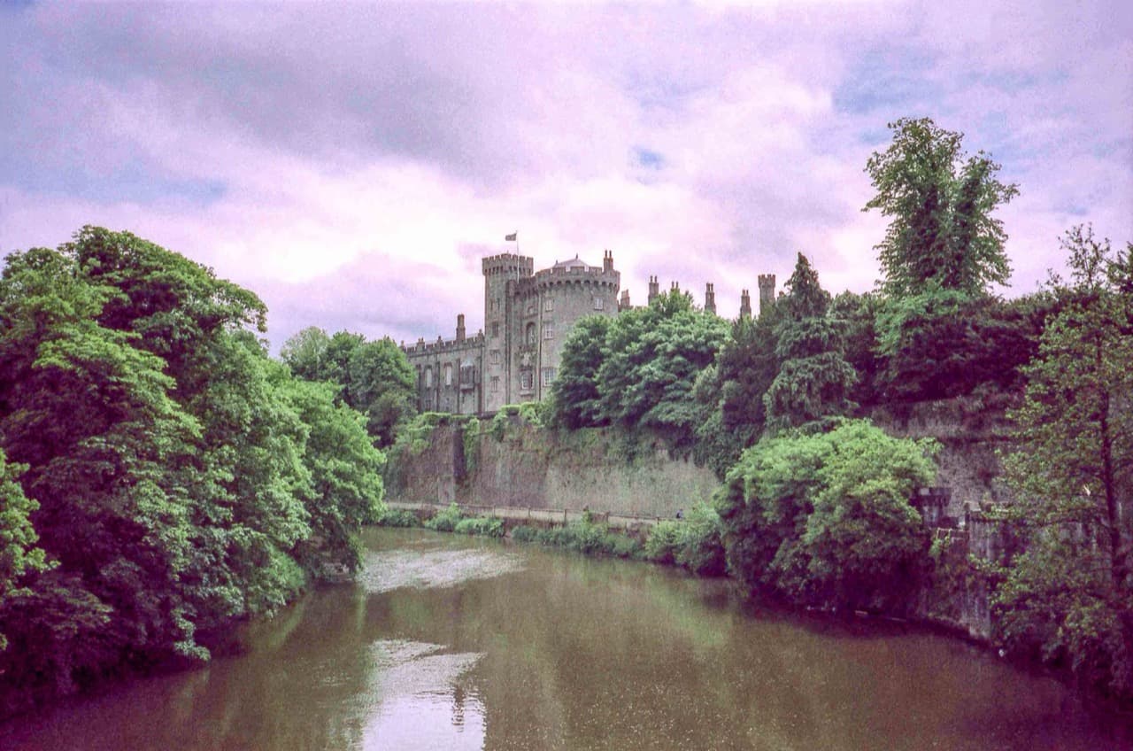The imposing stone towers of Anglo-Norman Kilkenny Castle standing over the River Nore