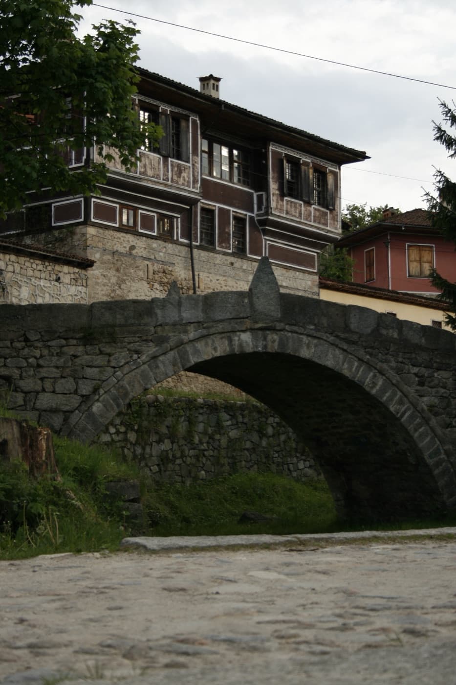 The vibrant blue painted facade and curved timber eaves of a National Revival mansion in historic Koprivshtitsa