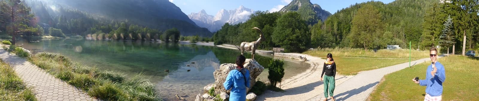 The bronze statue of the mythical horned chamois Zlatorog standing guard on the shore of Lake Jasna beneath the razor-sharp limestone peaks of the Julian Alps