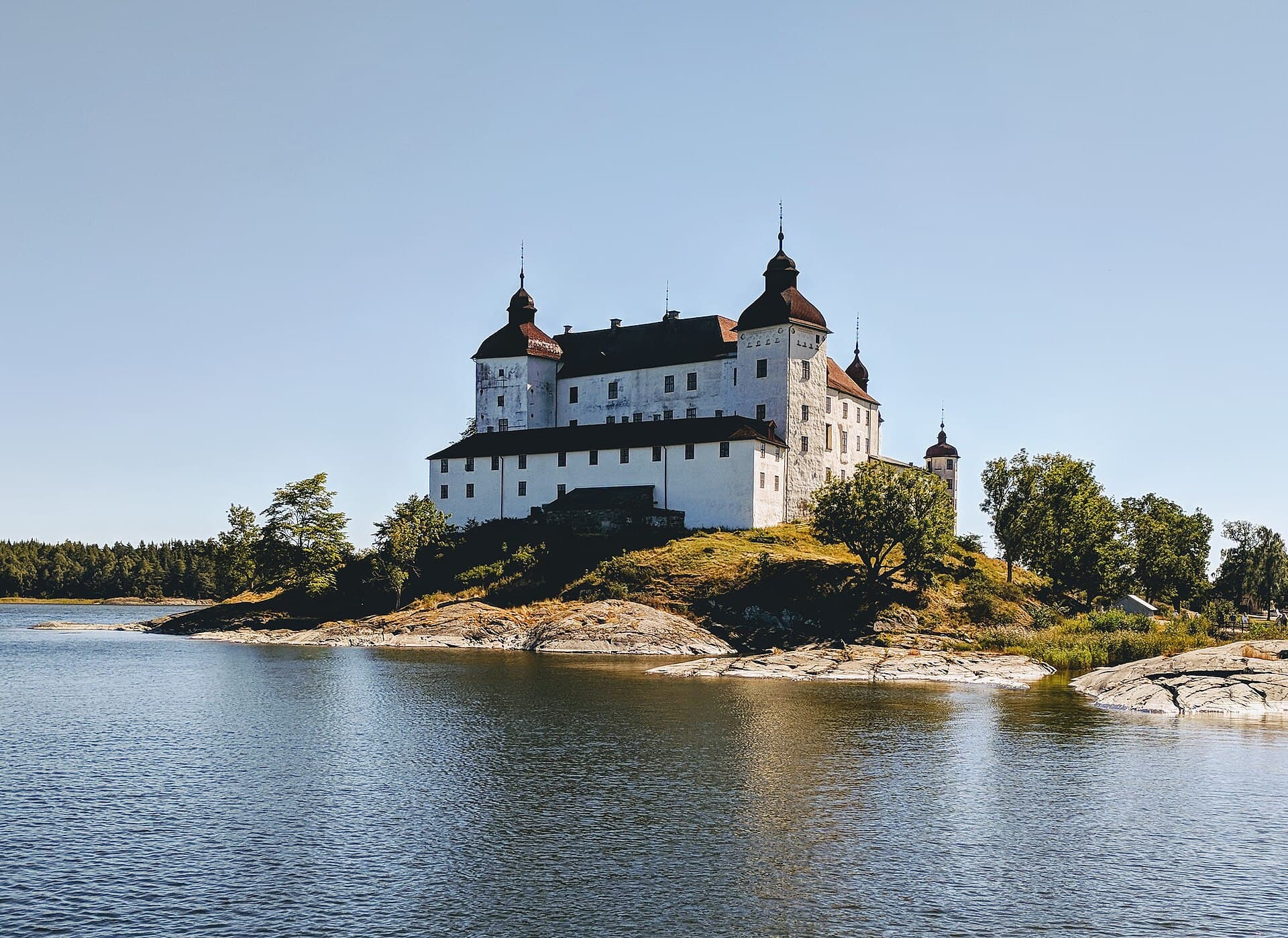 Whitewashed Baroque towers of Läckö Castle reflected in the waters of Lake Vänern on Kållandsö