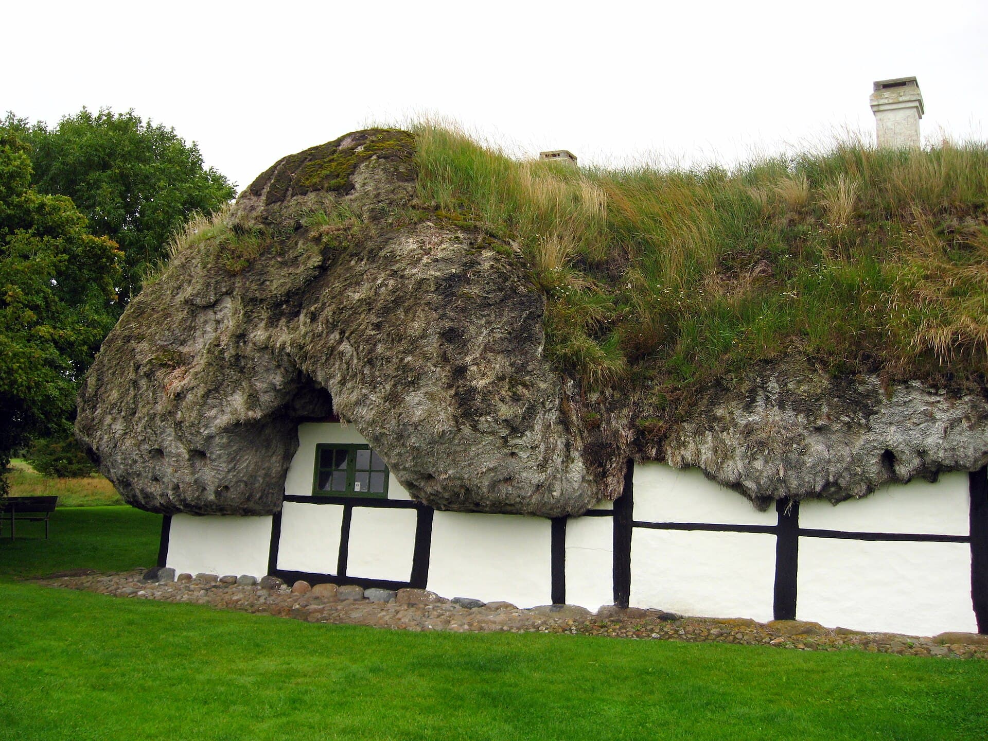 Silvery eelgrass seaweed roof (tangtag) resting heavily on a historic timber-framed cottage on Læsø.