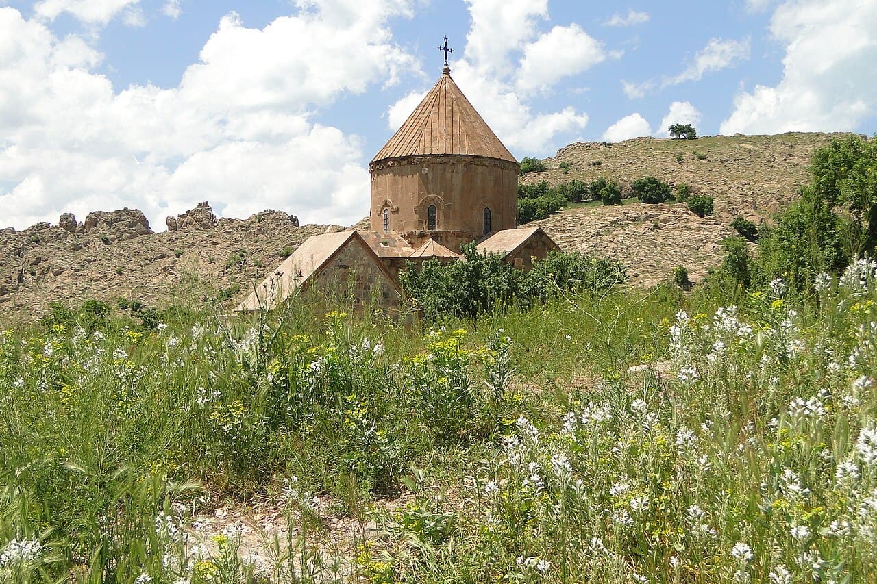 10th-century Armenian Church of the Holy Cross on Akdamar Island surrounded by the turquoise waters of Lake Van and snow-capped peaks