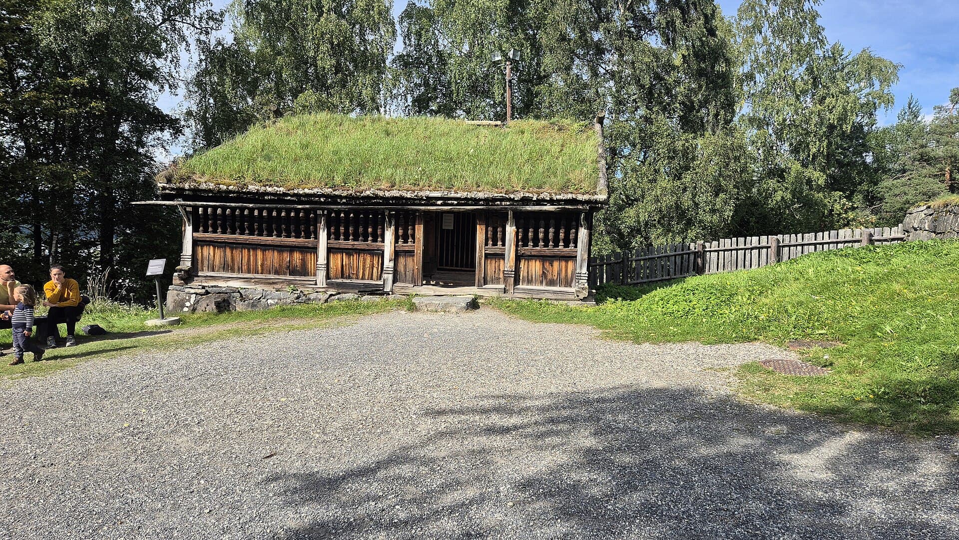 Historic timber farmsteads and sunlit meadows at the Maihaugen Open Air Museum in Lillehammer.