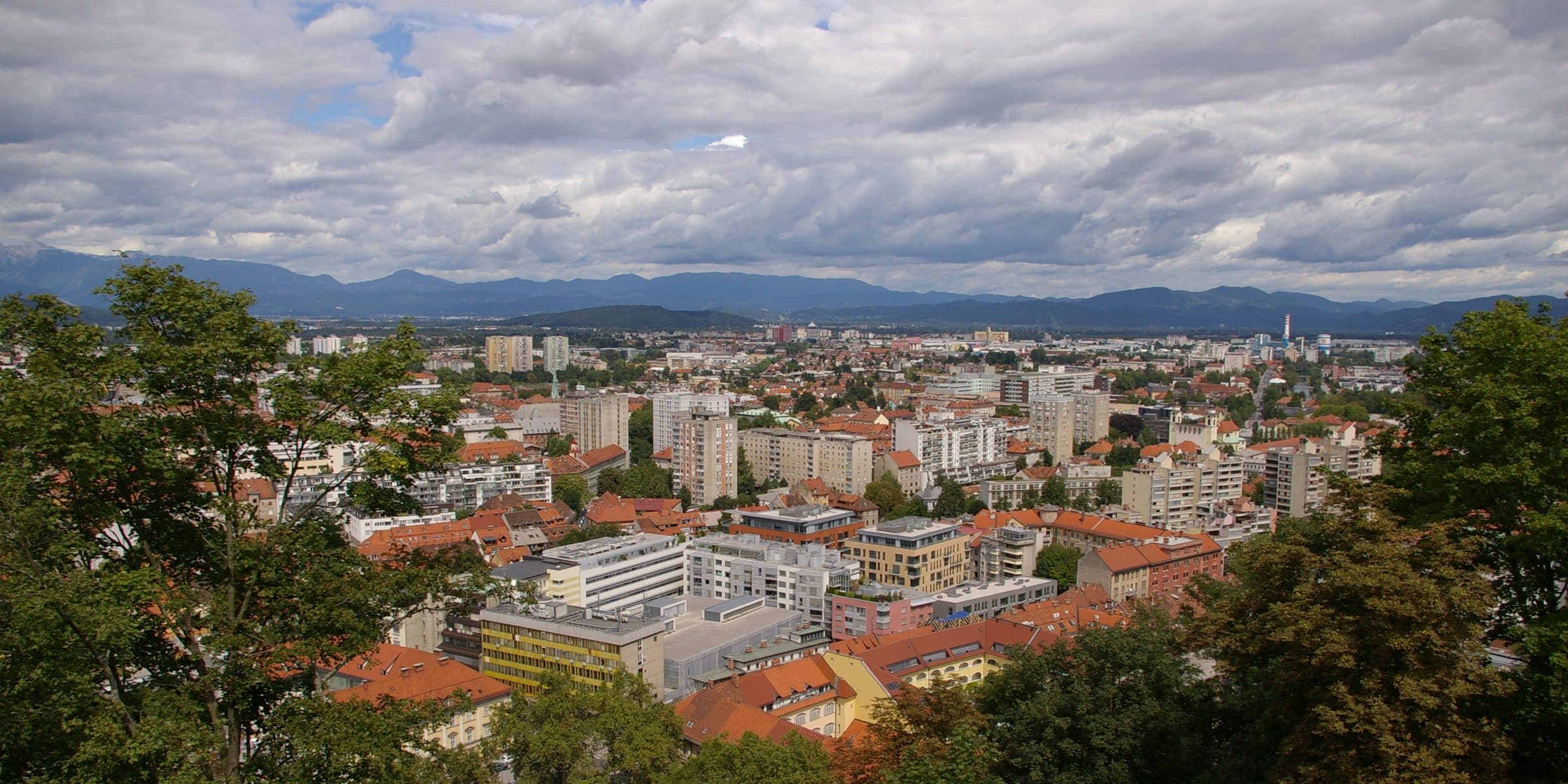 Ljubljana's rooftops and church towers with the Alps on the horizon