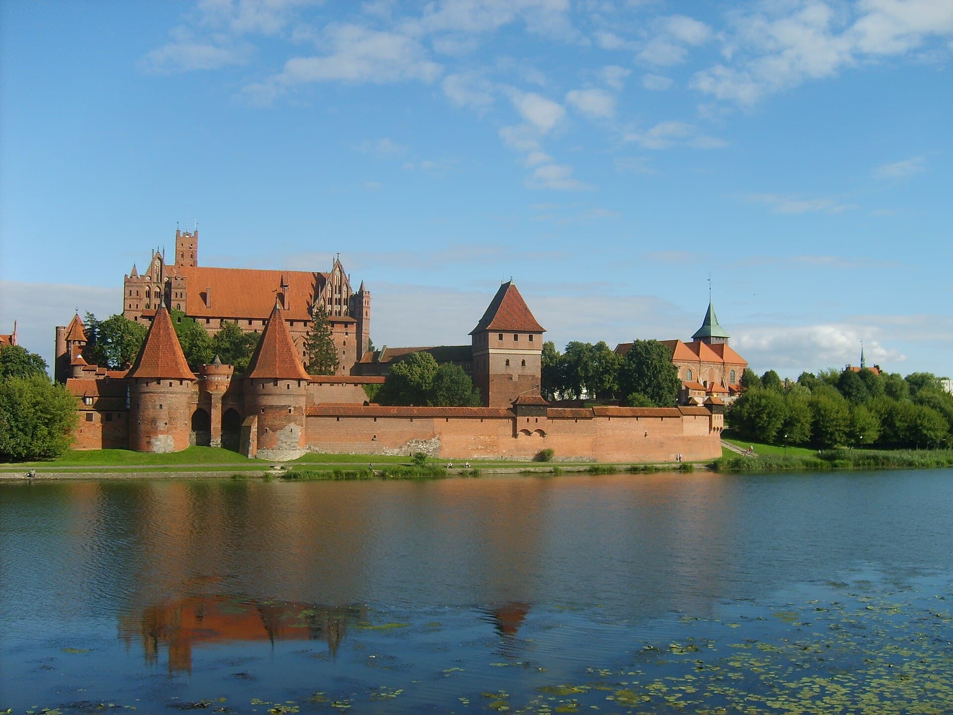 The immense red-brick fortified walls and towers of Malbork Castle above the Nogat River