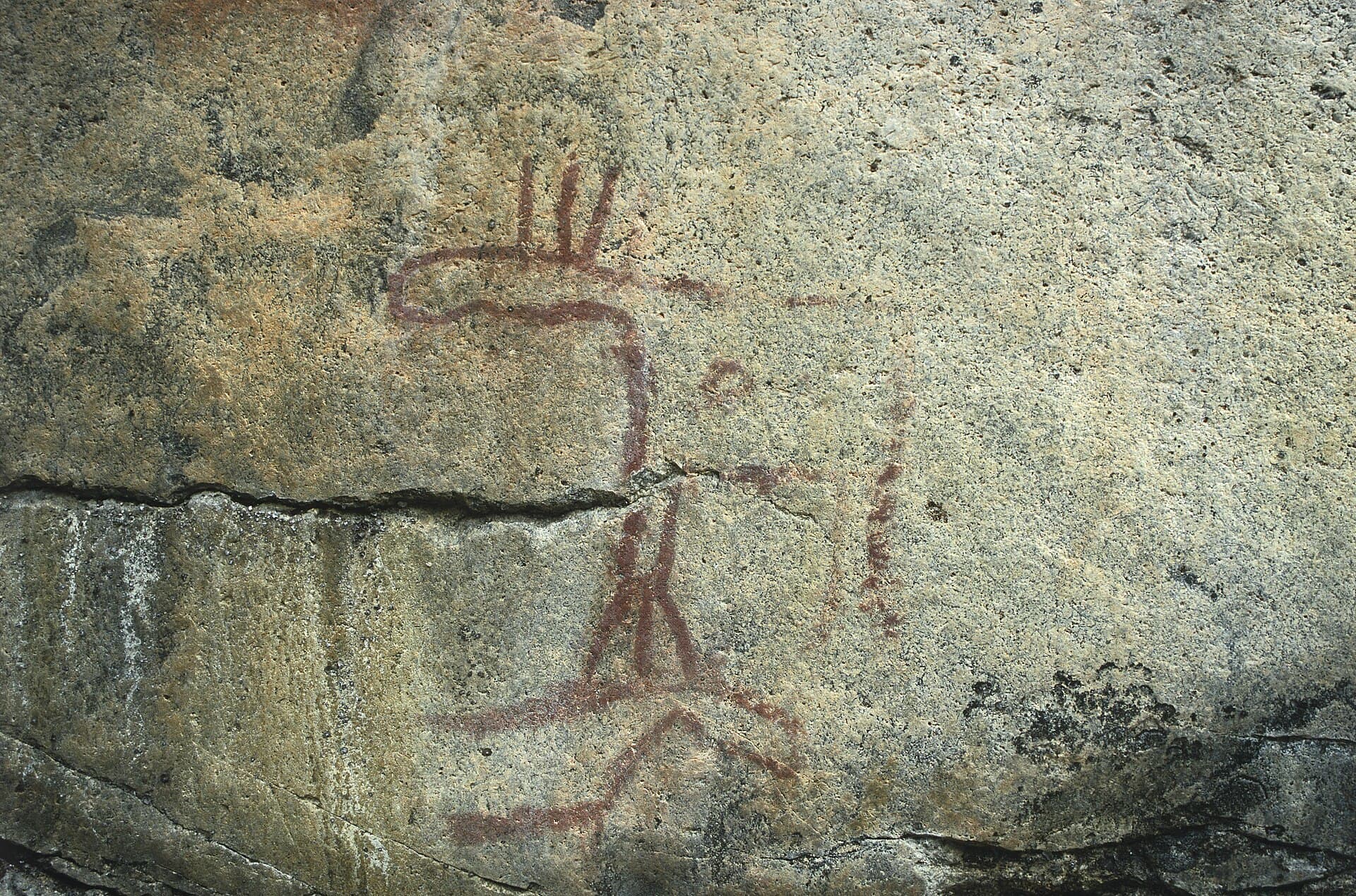 Prehistoric red ochre rock paintings of elks and human figures on the cliff wall at Astuvansalmi near Mikkeli
