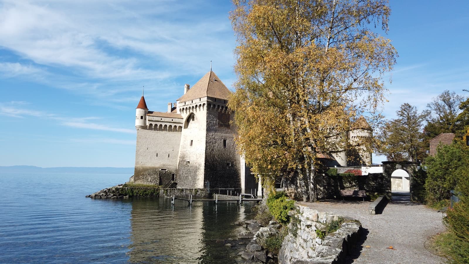 Chillon Castle perched on the shoreline of Lake Geneva against alpine foothills