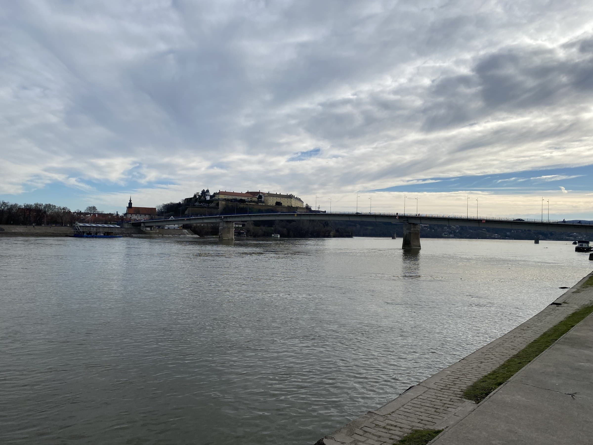 Petrovaradin Fortress clock tower overlooking the wide Danube river and Novi Sad skyline