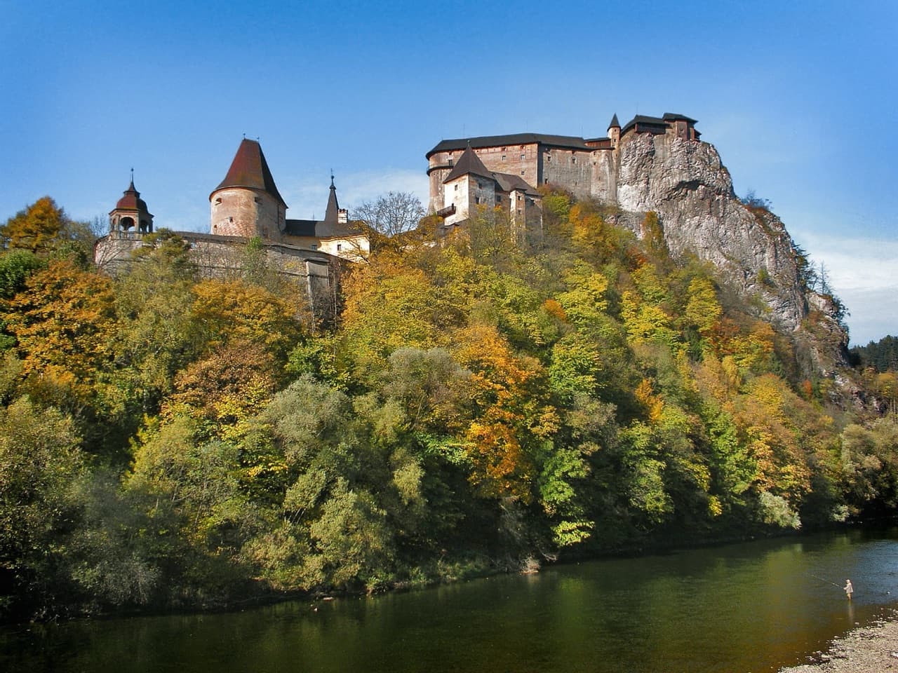 The dramatic multi-tiered fortress of Orava Castle perched atop a high rocky limestone cliff