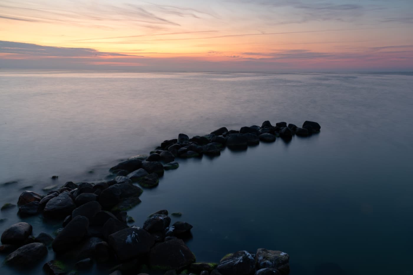 The historic 470-metre wooden sea pier extending into the Baltic waves at sunset in Palanga