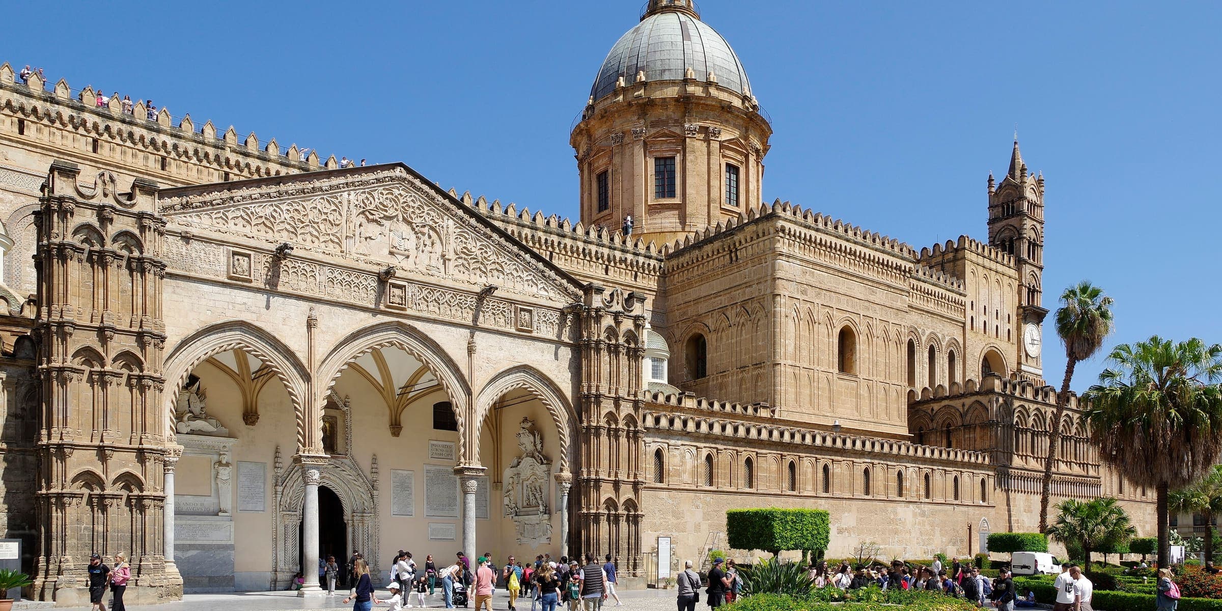 Palermo Cathedral's Arab-Norman facade and dome among palm trees
