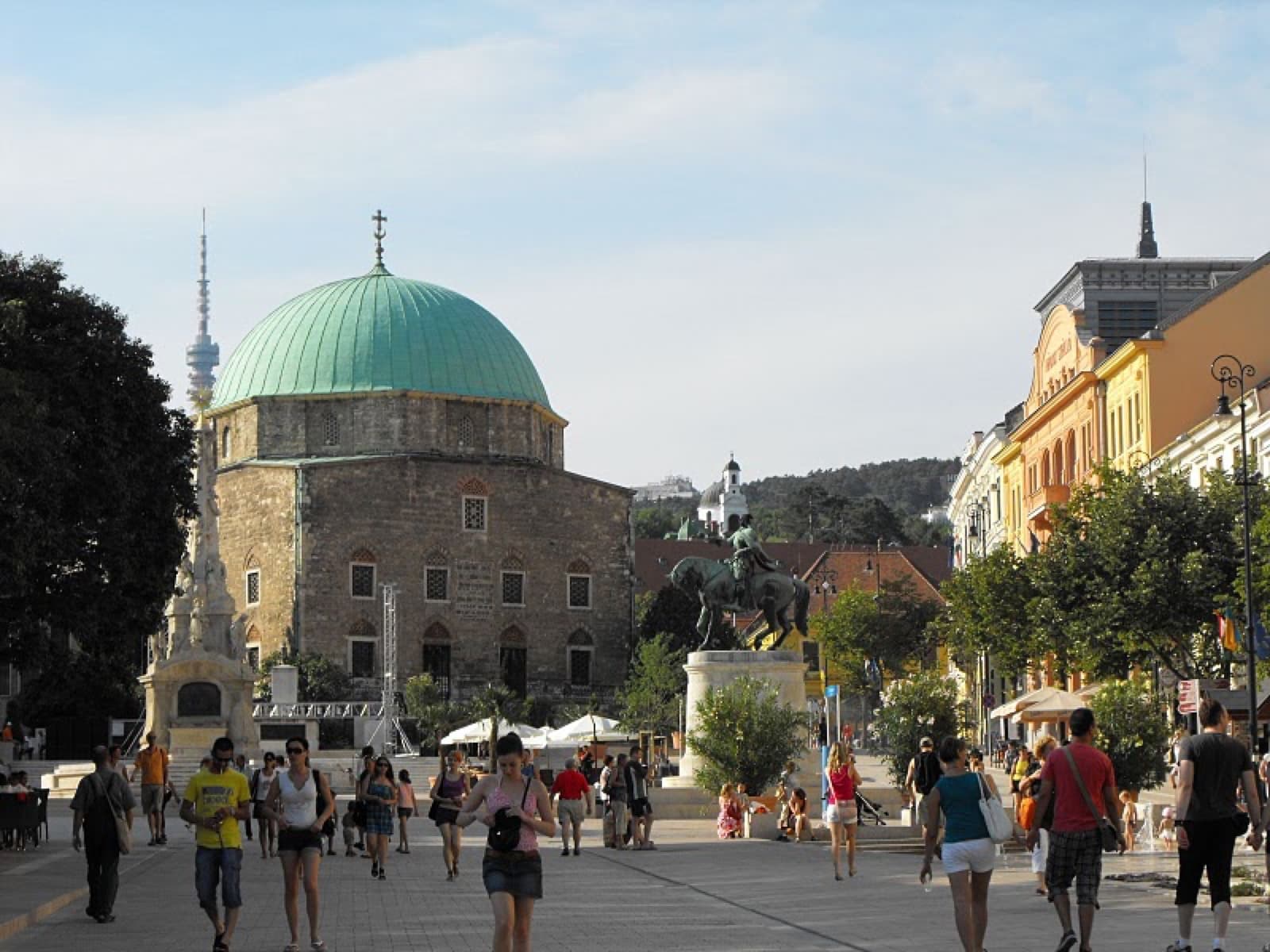 The distinctive green copper dome and arched windows of the Mosque of Pasha Qasim on Széchenyi Square in Pécs
