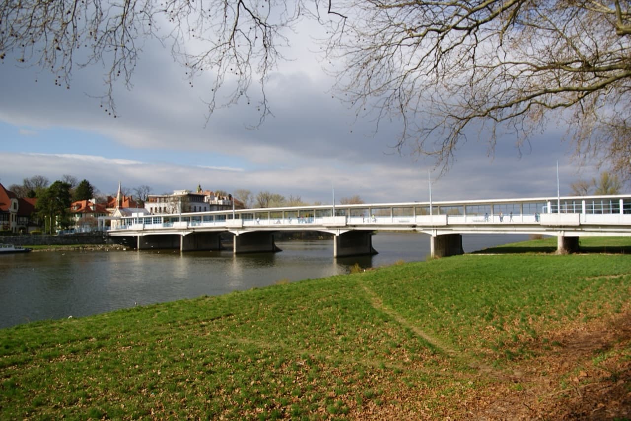 The elegant Colonnade Bridge crossing the Váh River into the lush green thermal park of Spa Island in Piešťany