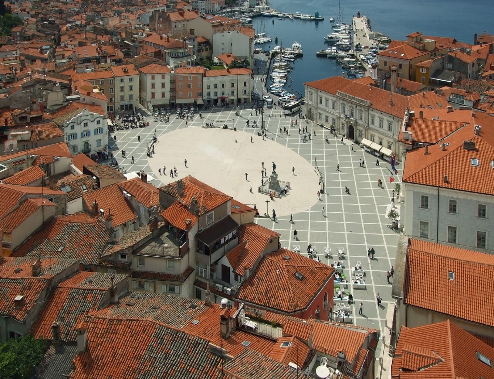 The pastel Venetian townhouses and bell tower of Saint George's Church crowning the rocky Piran peninsula jutting into the Adriatic