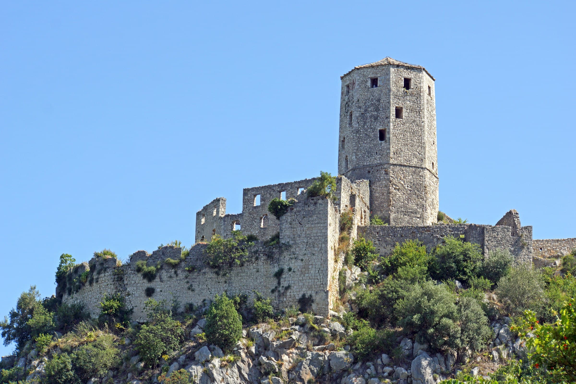 Steep stone amphitheatre of medieval fortress towers and Ottoman houses overlooking the Neretva in Počitelj