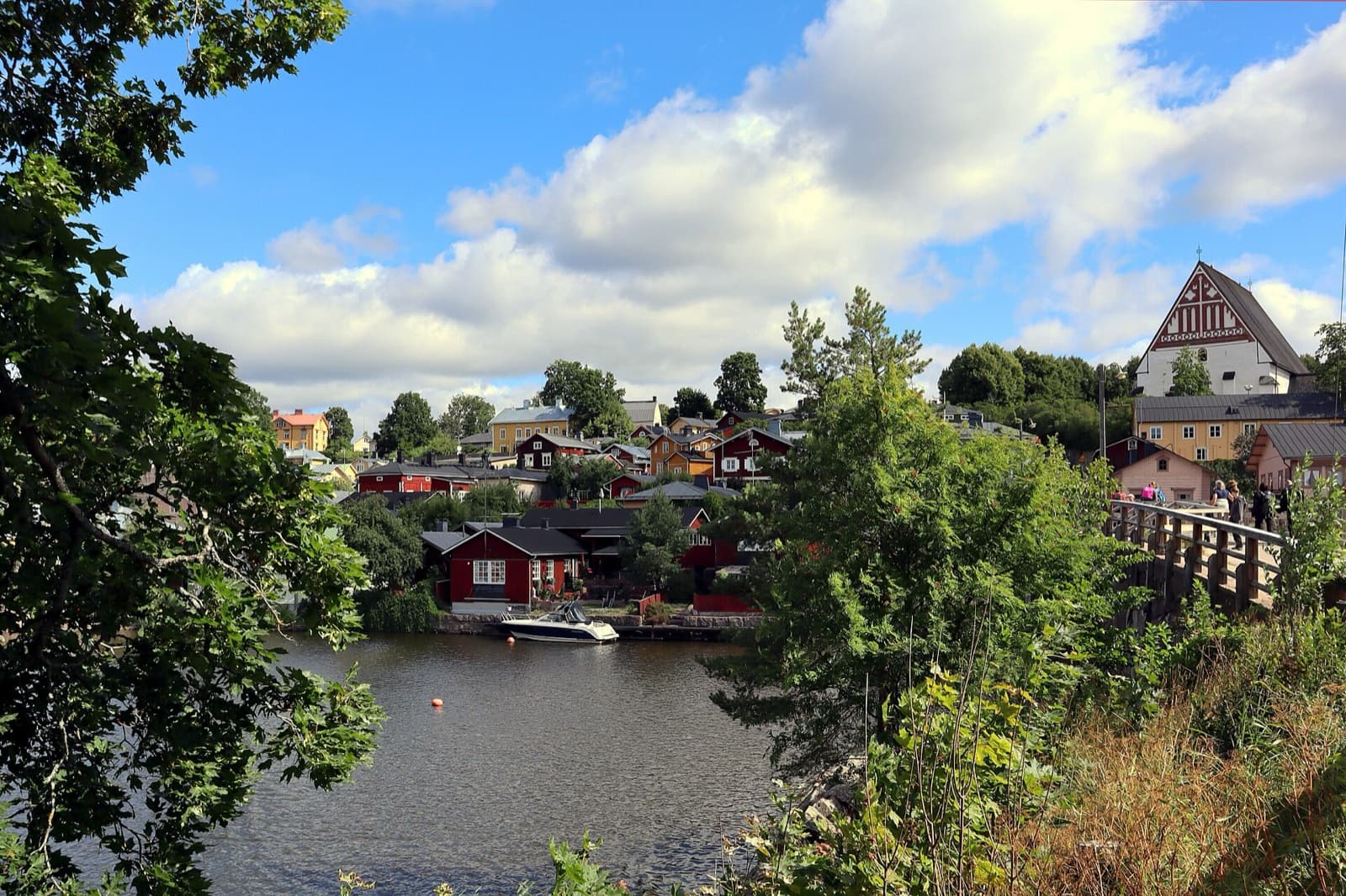 The iconic red ochre wooden shore warehouses of Porvoo mirrored in the calm waters of the Porvoonjoki River