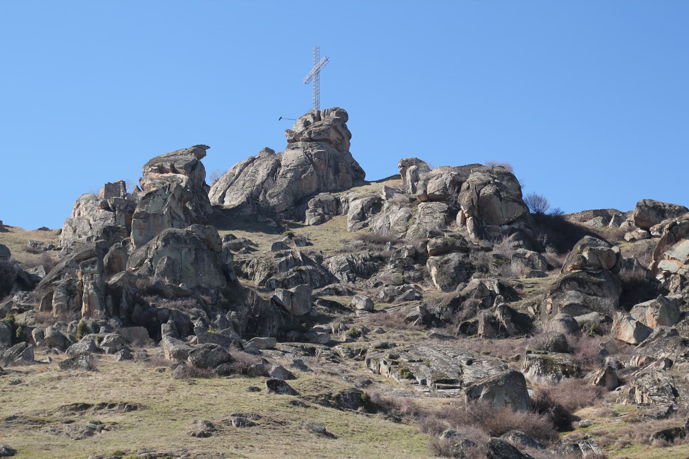 Rounded granite boulders rising above the roofs of Prilep towards Marko's Towers