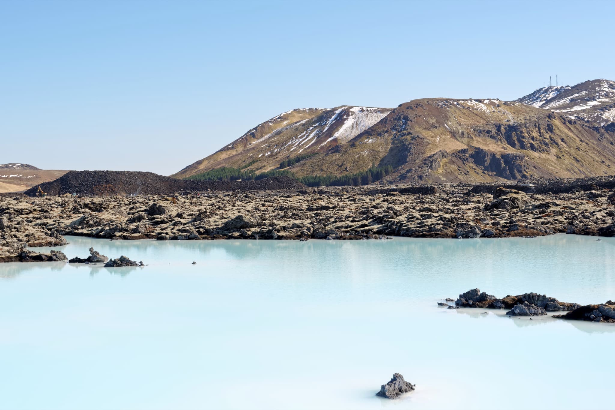 The mineral-rich milky blue waters of the Blue Lagoon surrounded by mossy volcanic lava in Reykjanes