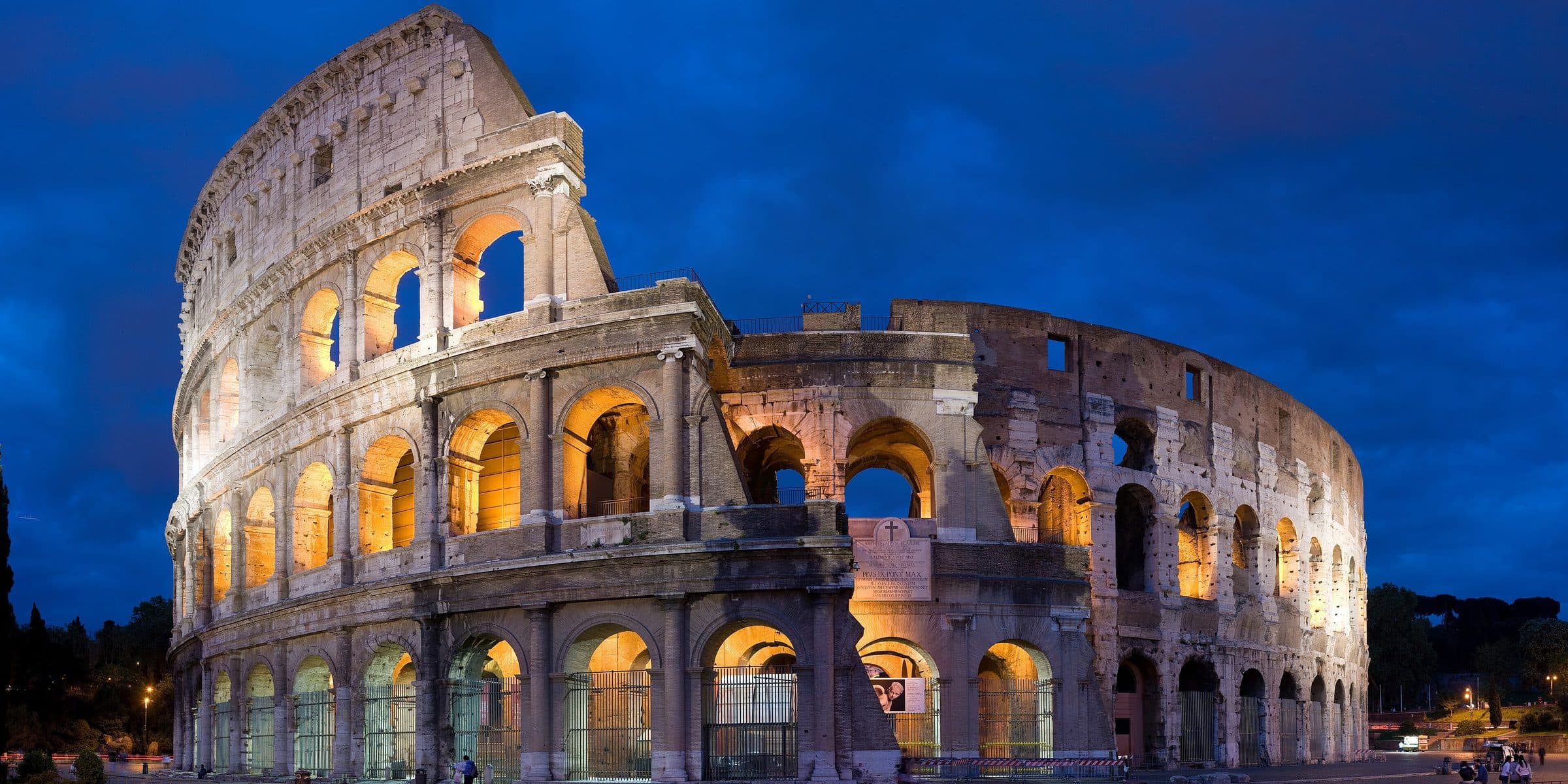 The Colosseum lit against a deep blue evening sky