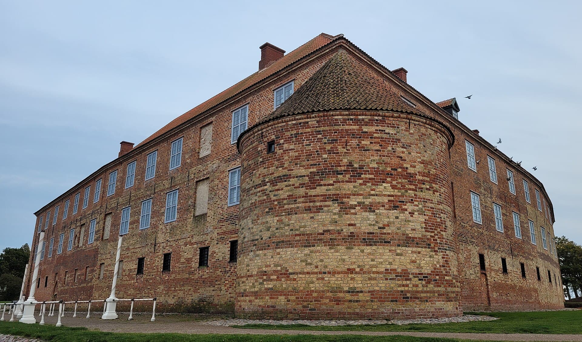 Moated red-brick walls and towers of Sønderborg Castle guarding the Alssund waterway on Als.