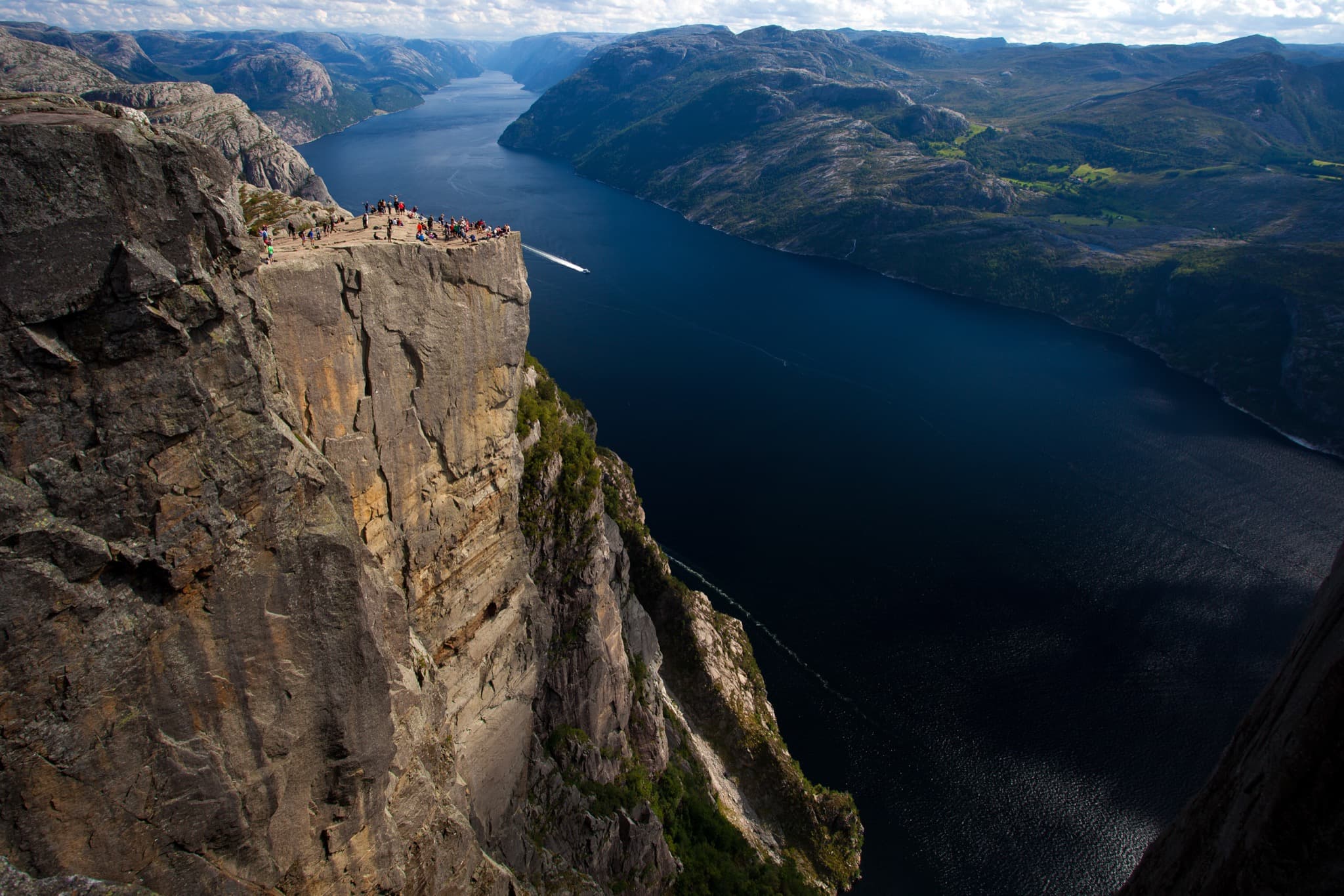 Iconic flat granite plateau of Preikestolen plunging 604 metres down to the blue waters of Lysefjord