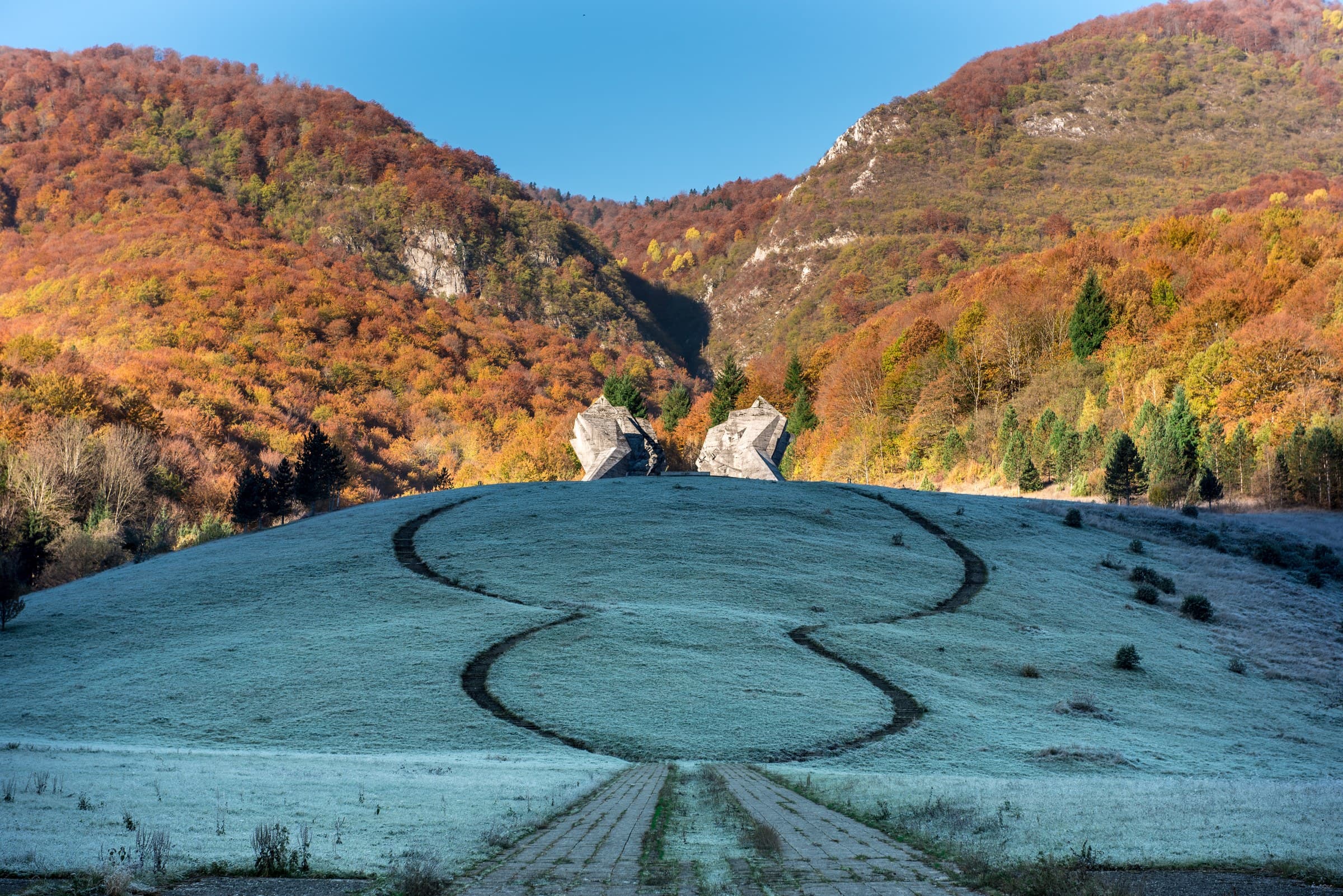 Monument to the Battle of the Sutjeska at Tjentište with the rugged limestone peaks of Maglić in the background