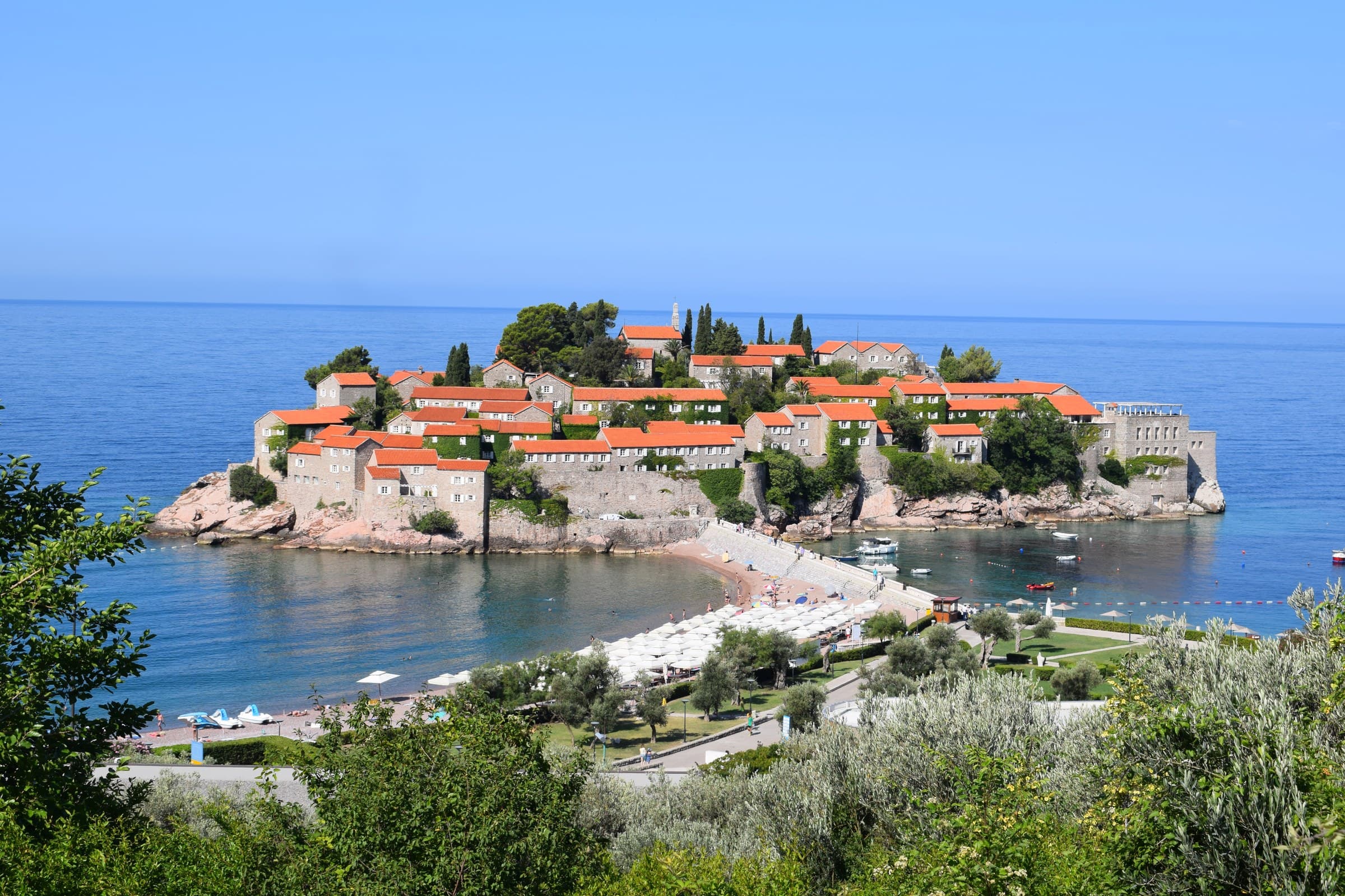 Fortified 15th-century stone village and pink sand tombolo causeway of Sveti Stefan in Montenegro