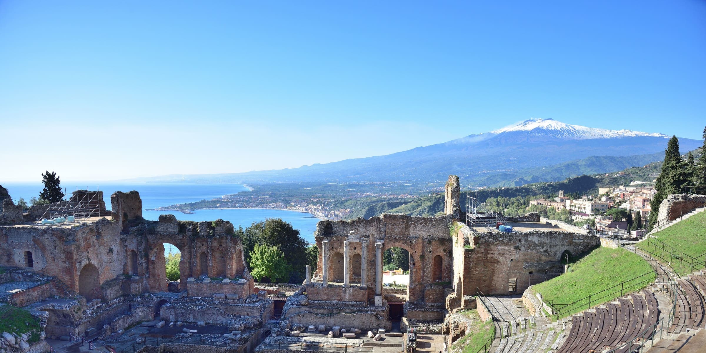 The Greek theatre at Taormina with the coast and snow-capped Etna behind