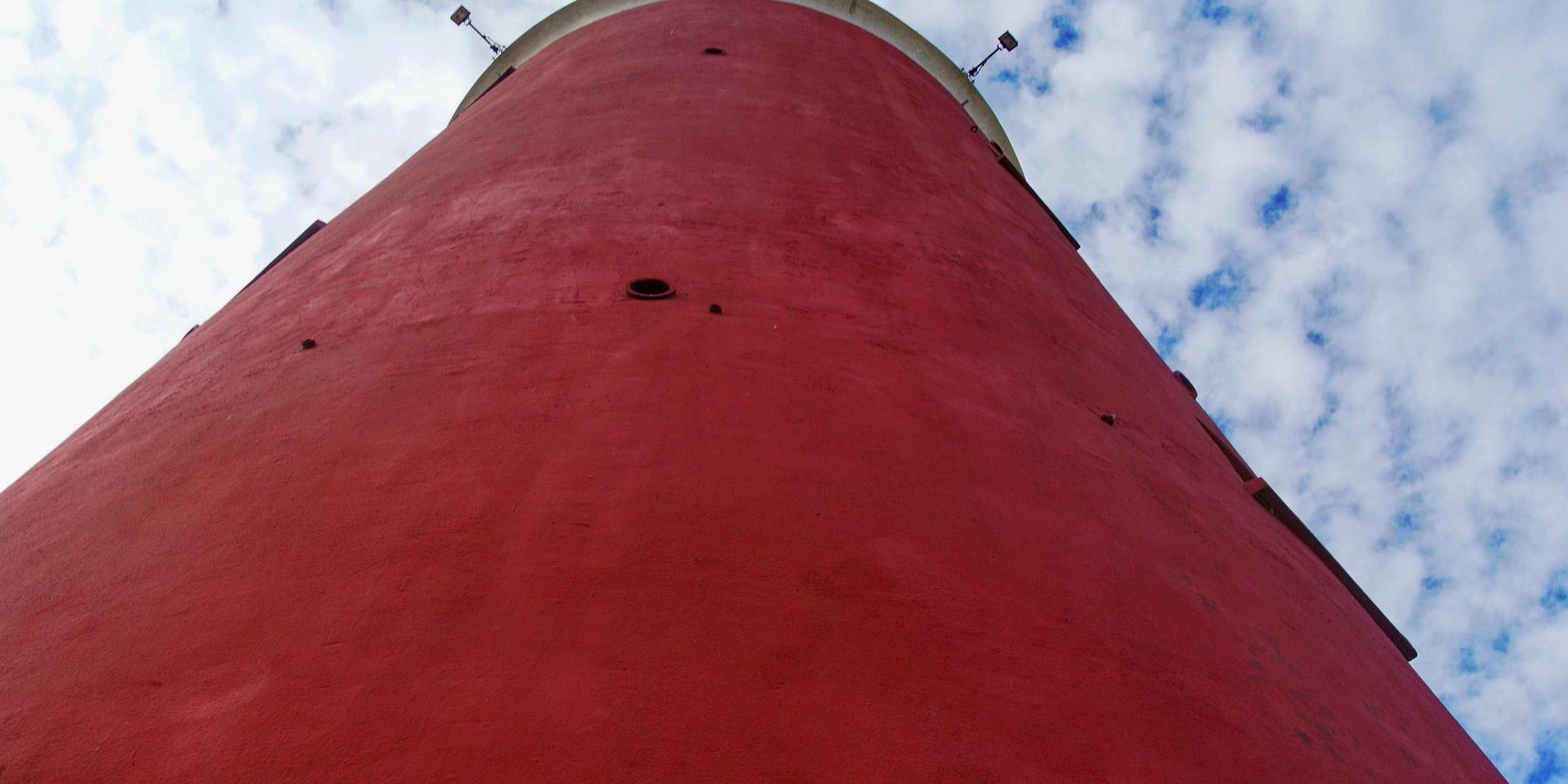 The bright red lighthouse rising above the sandy North Sea dunes at De Cocksdorp on Texel