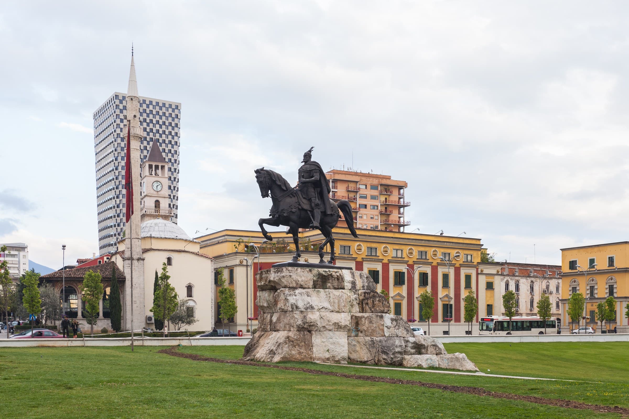 Monument to Skanderbeg in the centre of Skanderbeg Square with colourful modern buildings in Tirana
